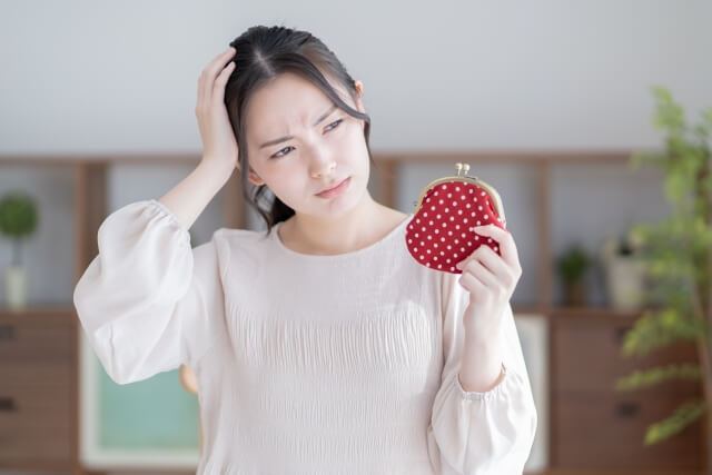 お財布を持って悩む女性