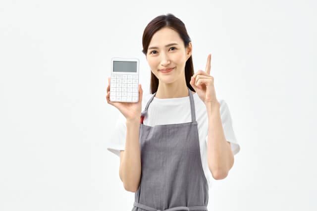電卓を持つ人差し指ポーズする主婦