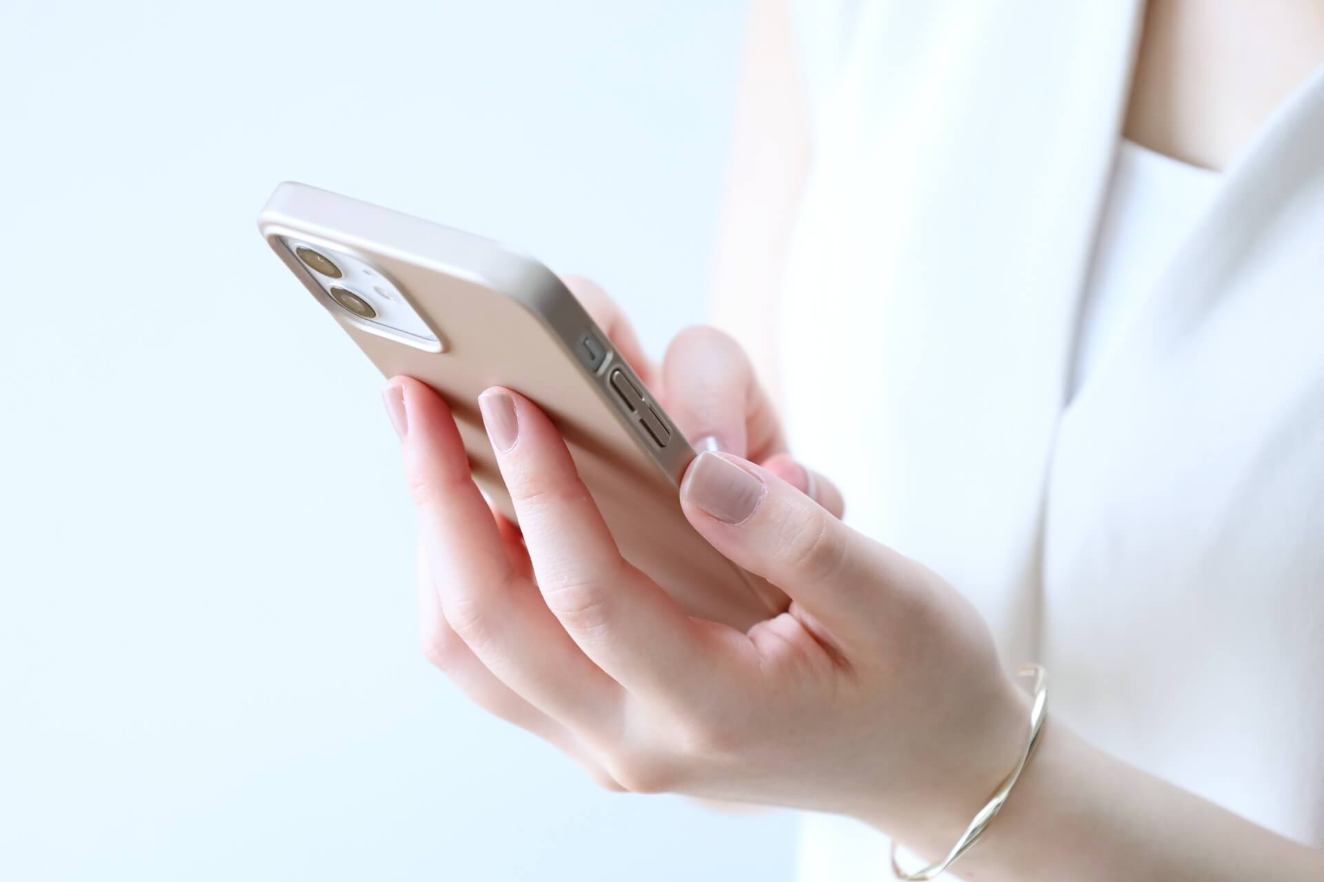 スマホを操作する女性の画像。