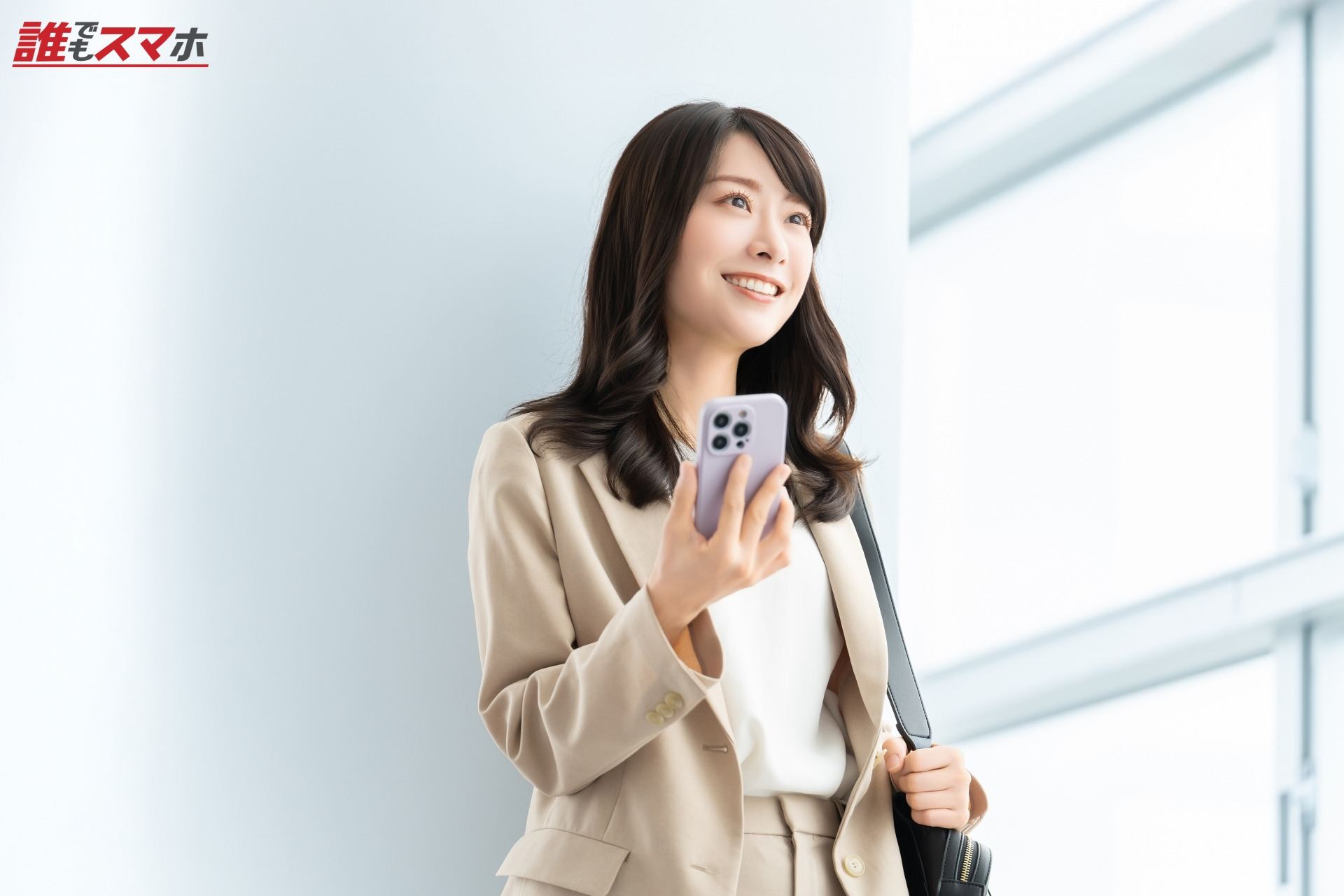 スマホを持つ笑顔の女性・ビジネスウーマン