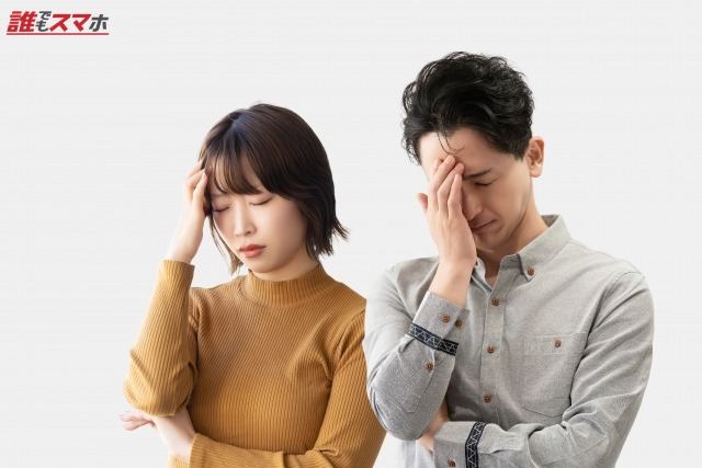 頭を押さえて悩む男女2人のビジネスマン