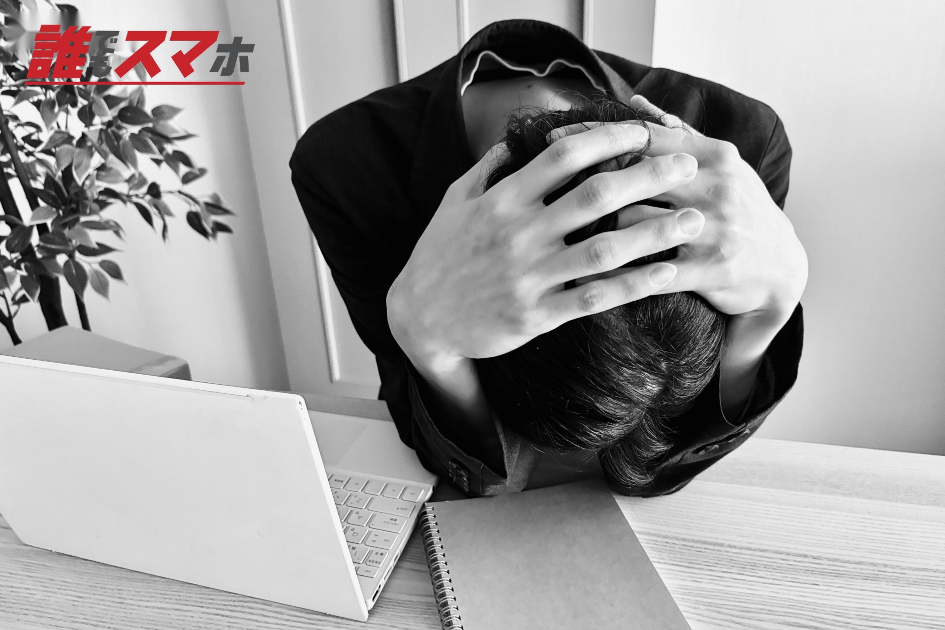 デスクで頭を抱える男性