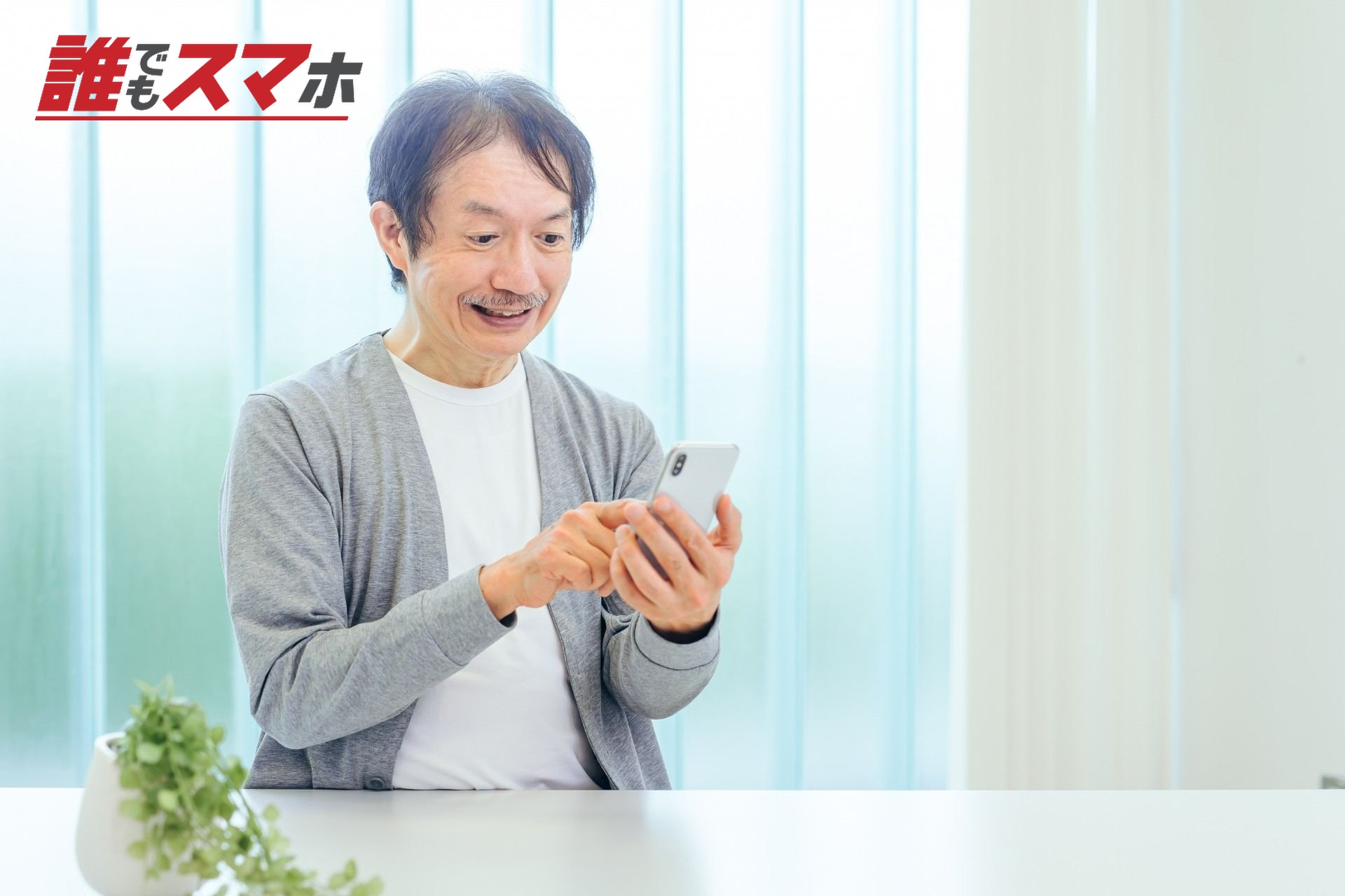 スマホを使う中高年男性(アプリ・笑顔)
