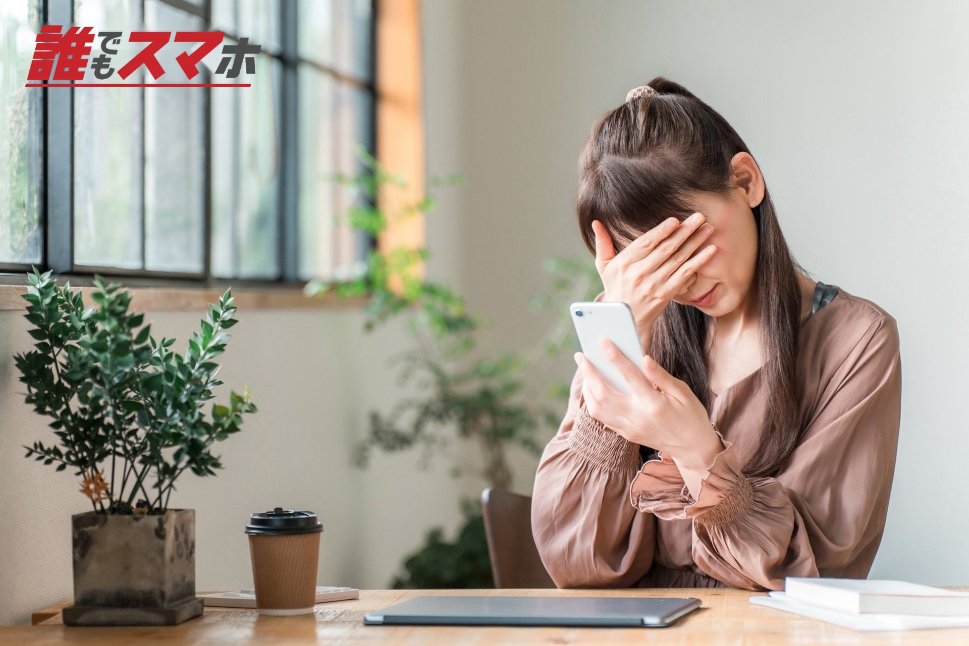 カフェでスマホを見てショックを受ける女性