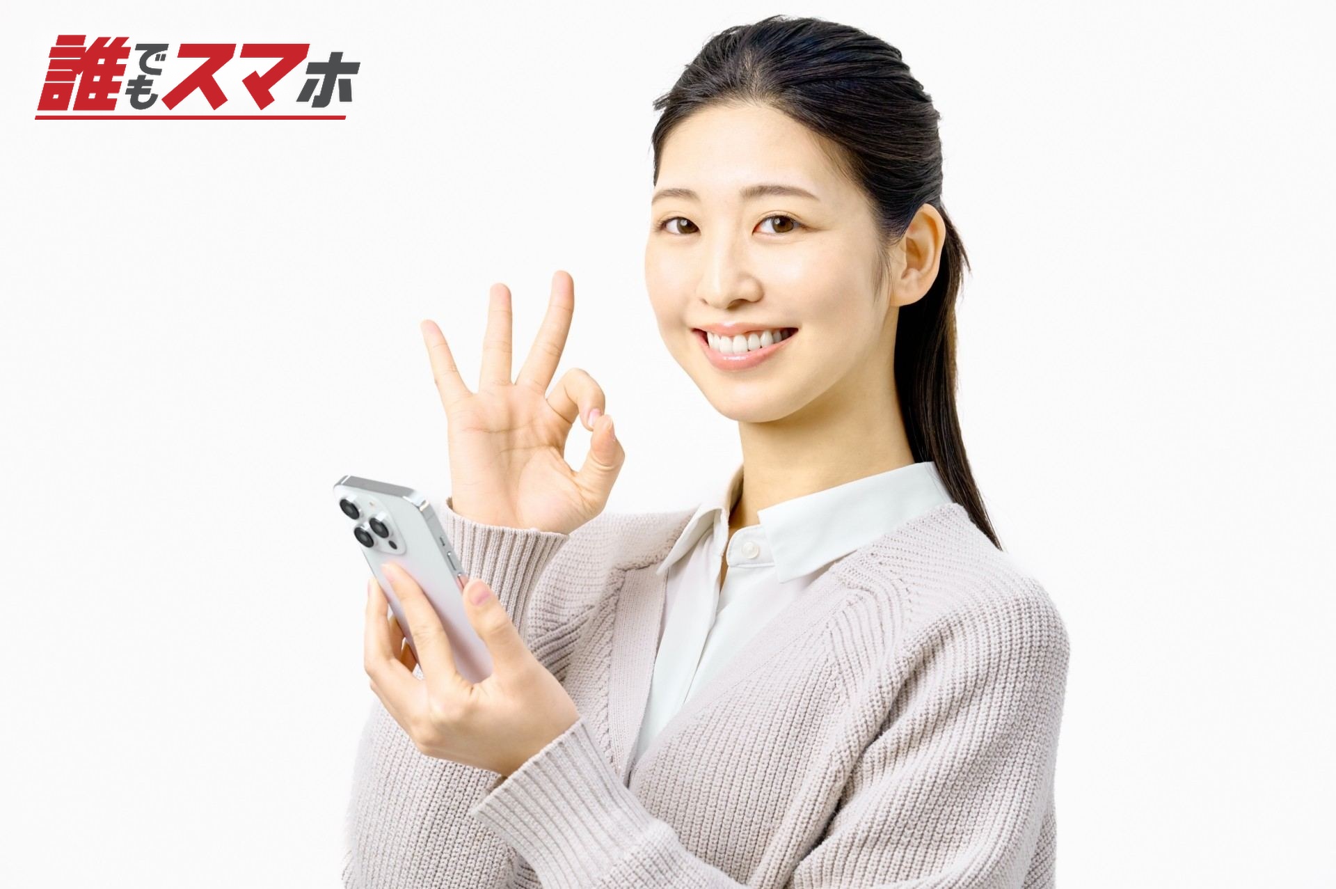 スマートフォンを持ちOKサインする女性