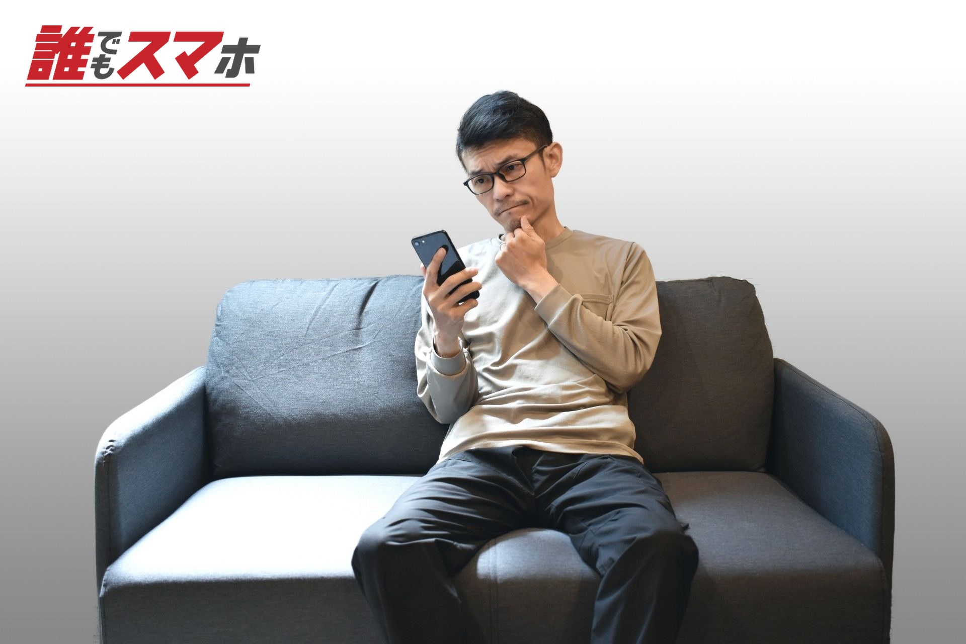 携帯電話を持ち悩む男性