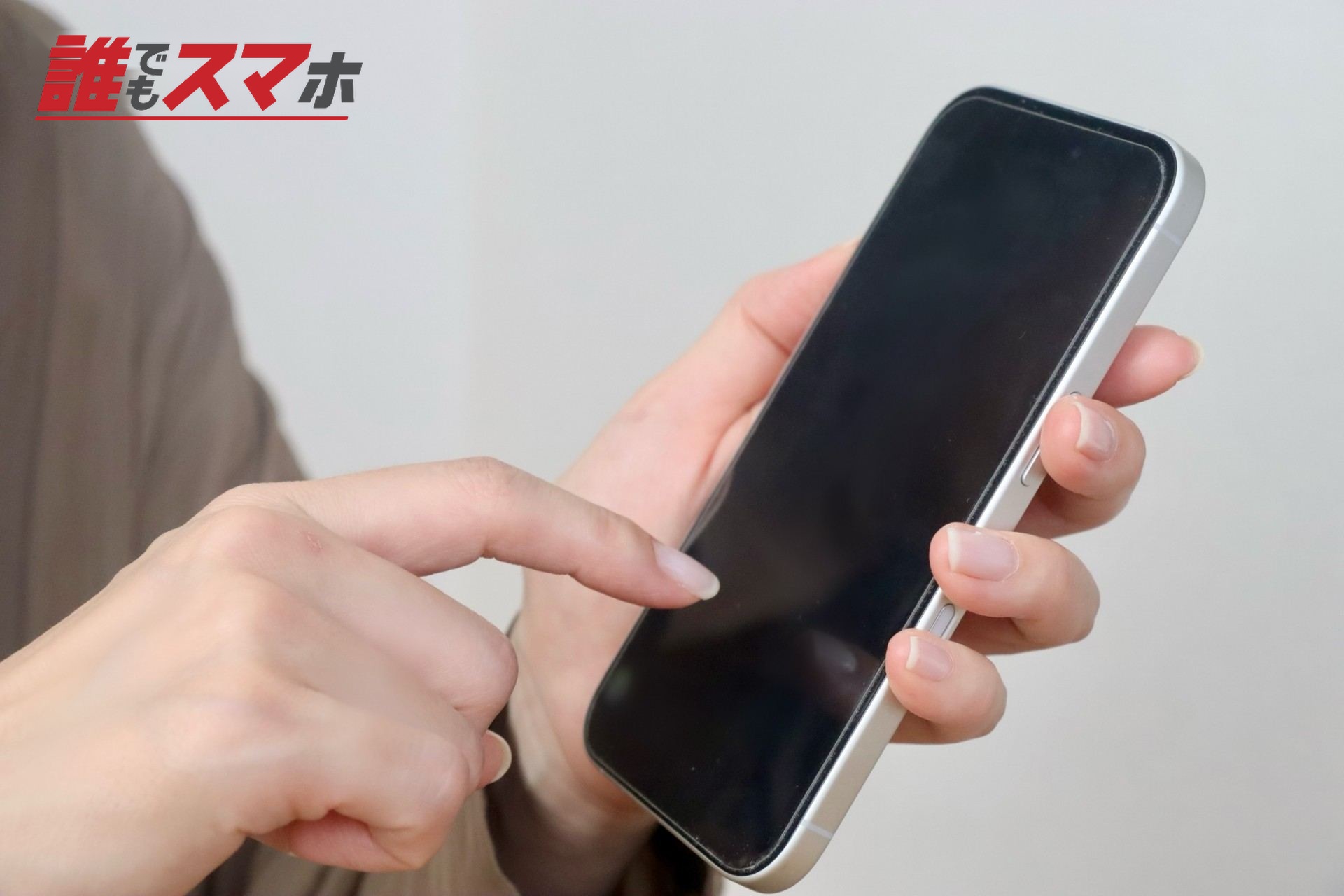 スマホを指さす女性