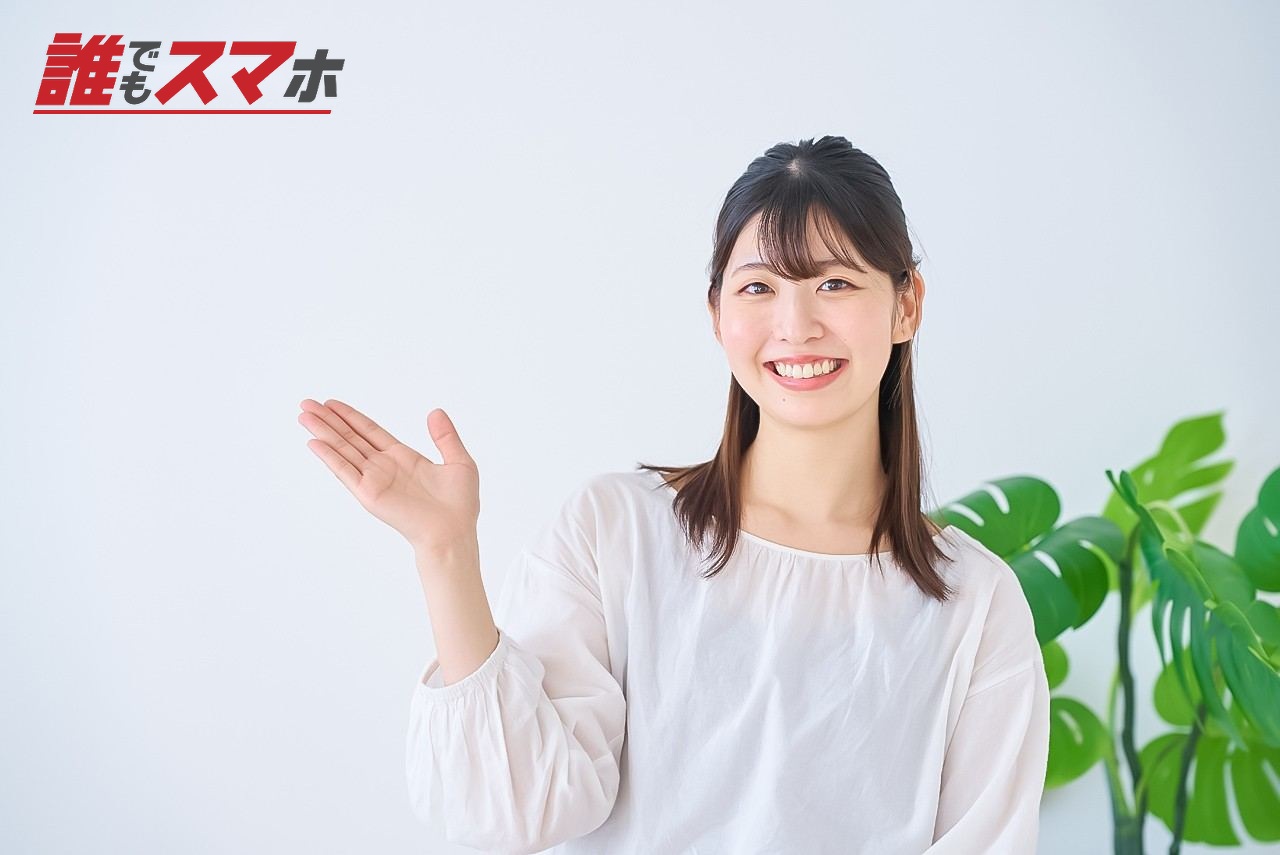 案内のポーズをする若い女性