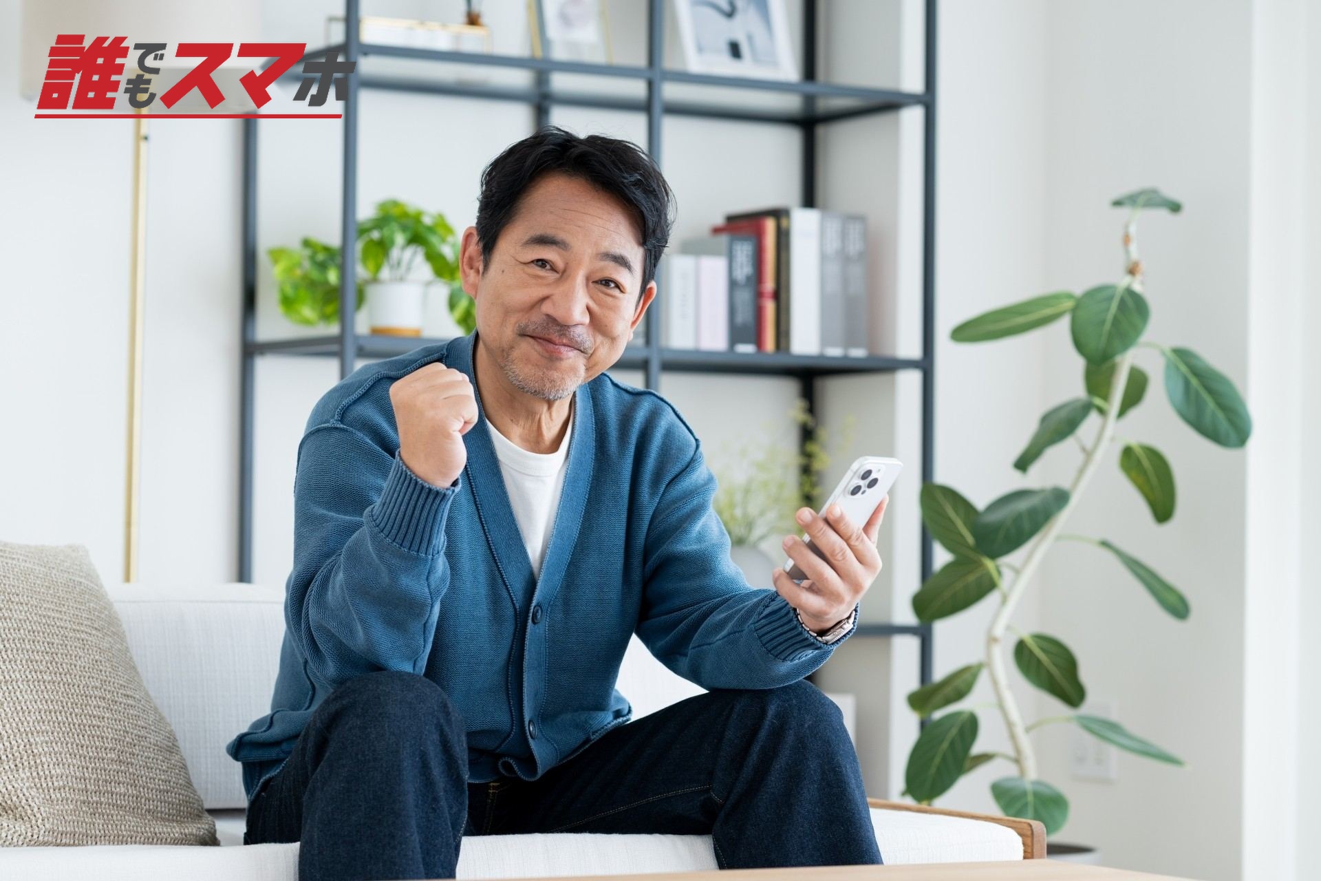 スマホでガッツポーズするミドルの男性