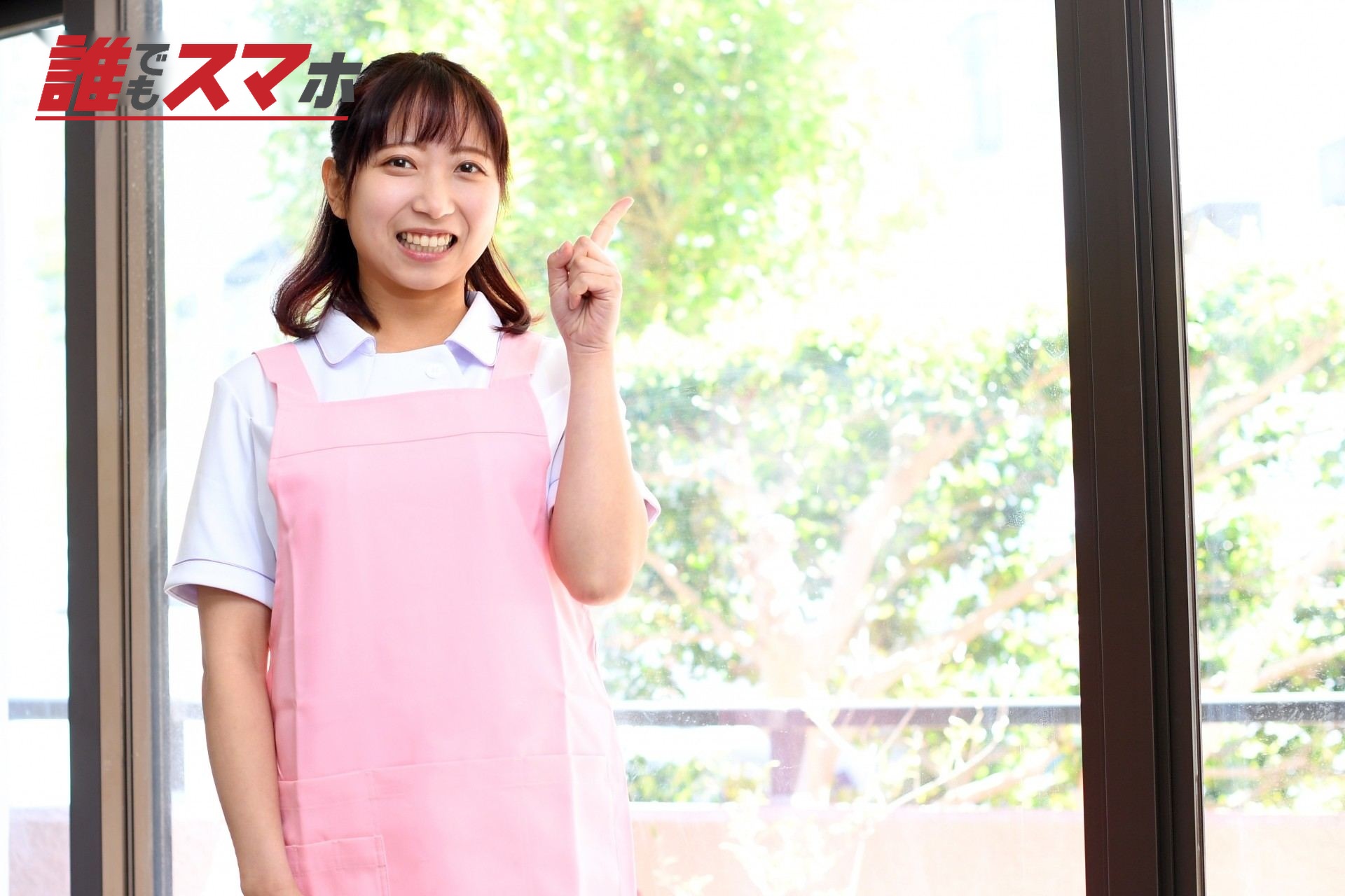 指差しをするエプロン姿の若い女性