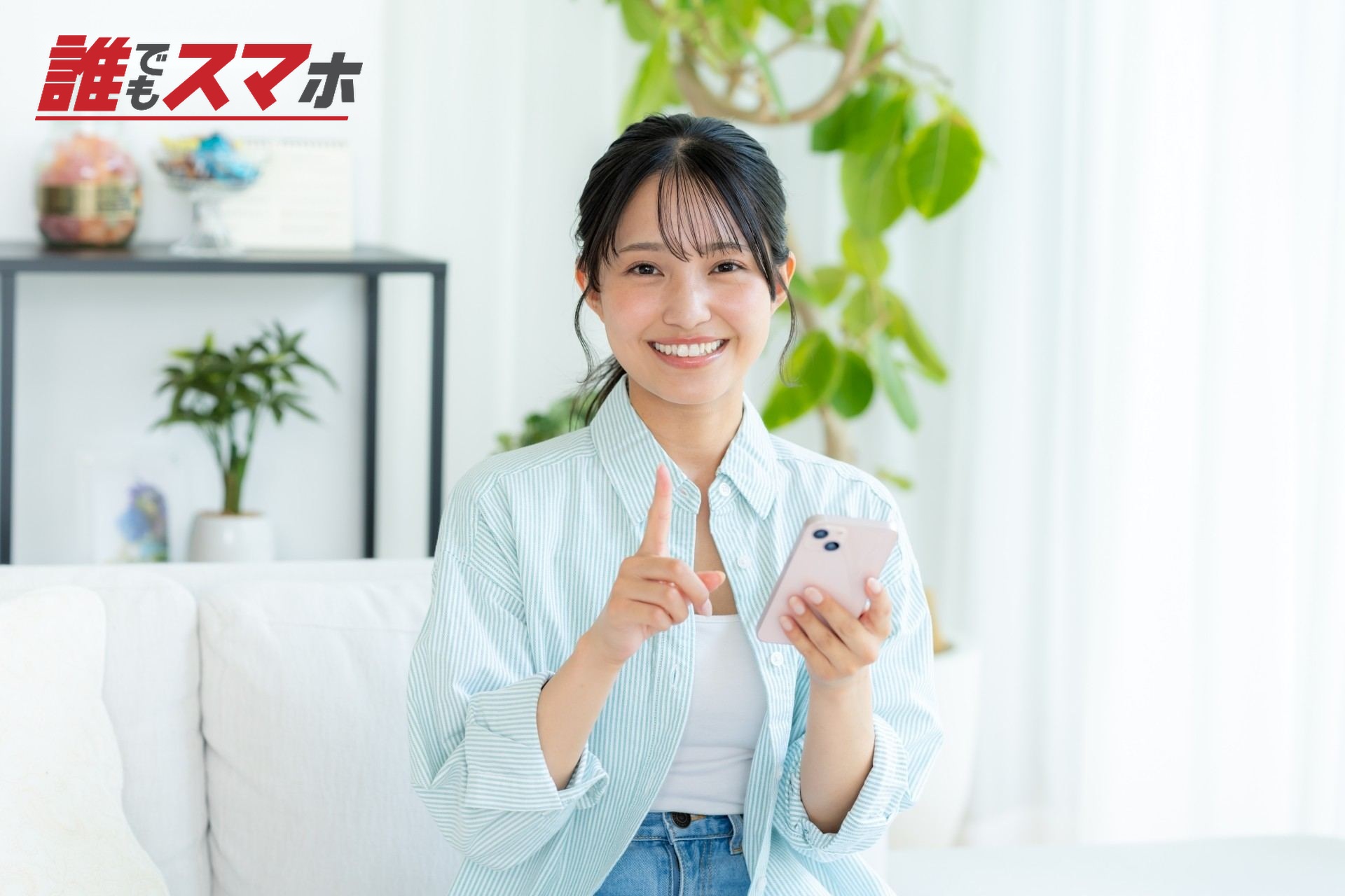 部屋でスマホを操作する若い女性
