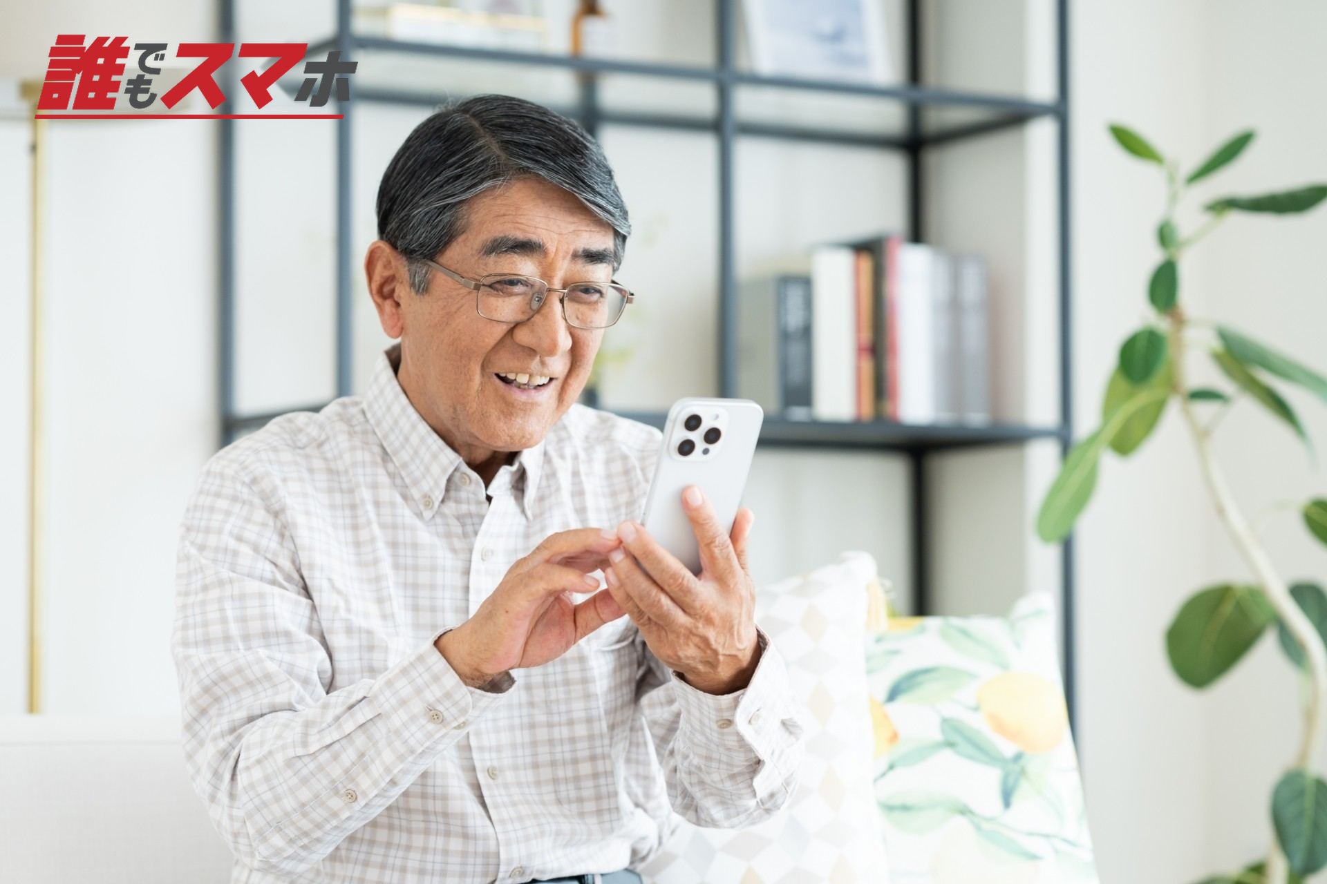リビングでスマホを使うシニアの男性