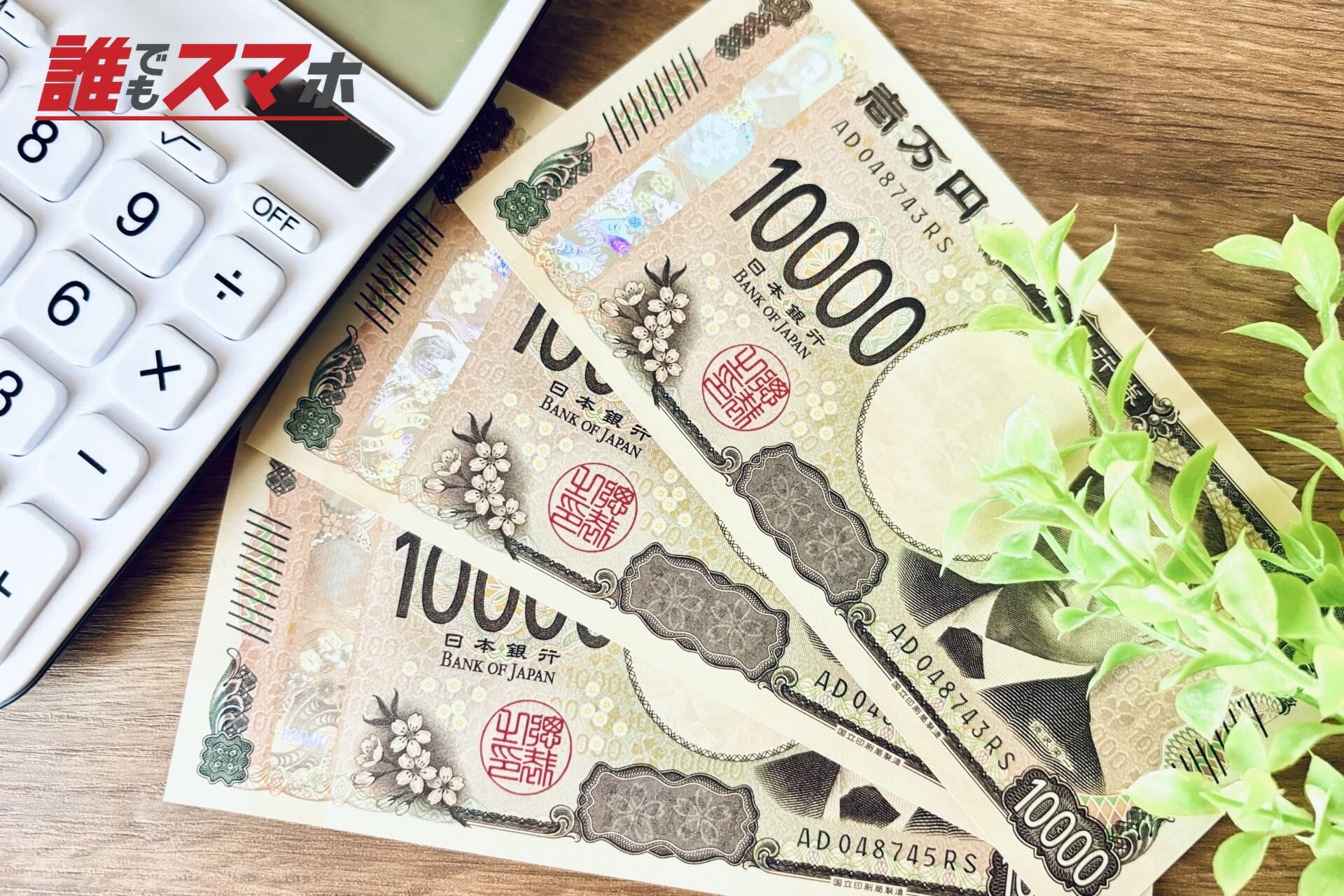 木目の机に現金1万円と電卓