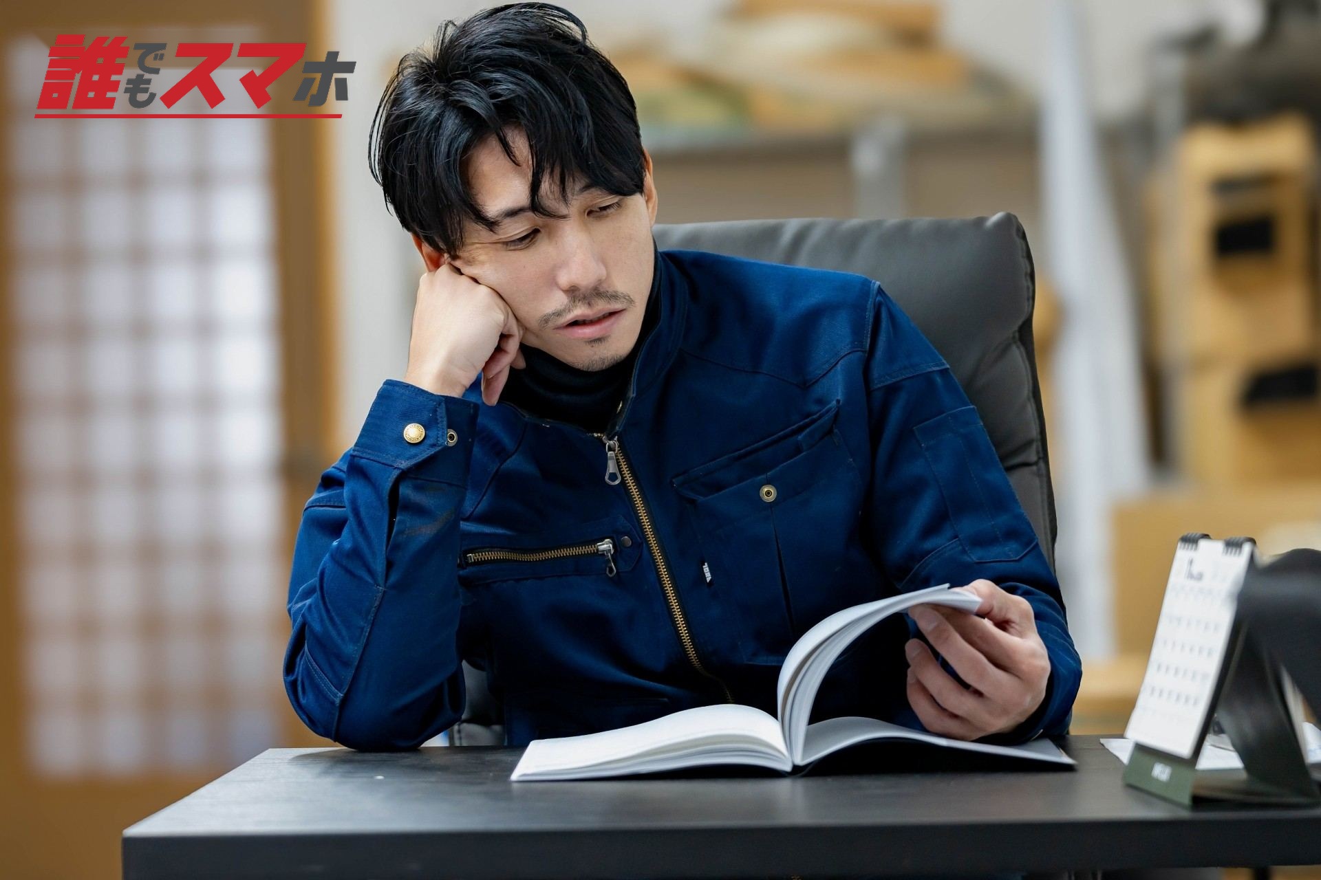 座って書類を確認する男性