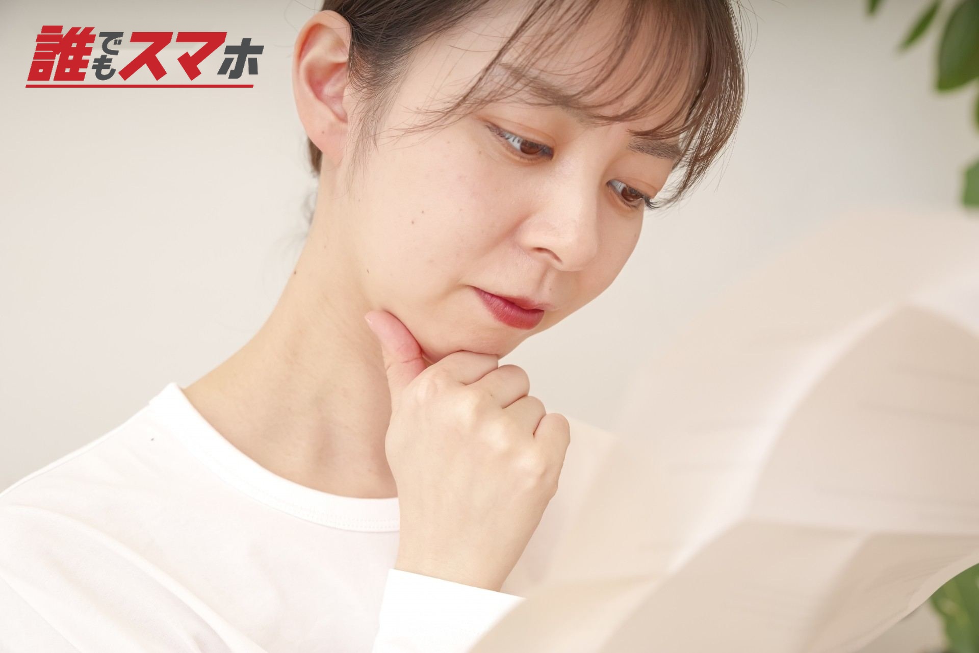 書類を見て複雑な表情をする女性