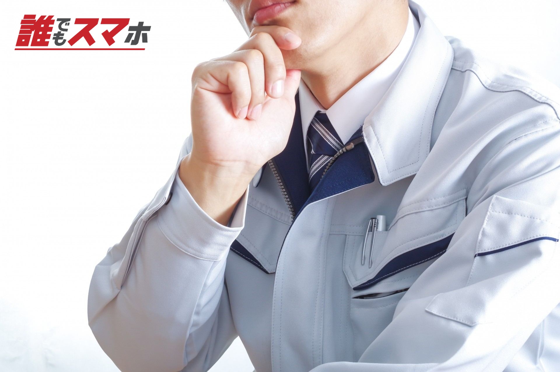 考え事をする作業服の男性