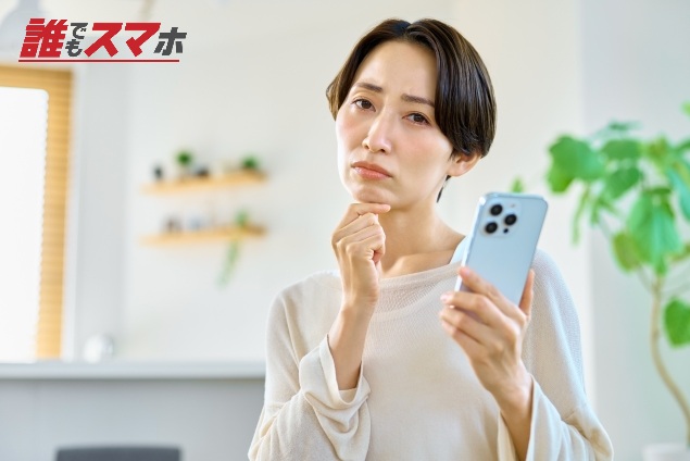 携帯を持って考える女性