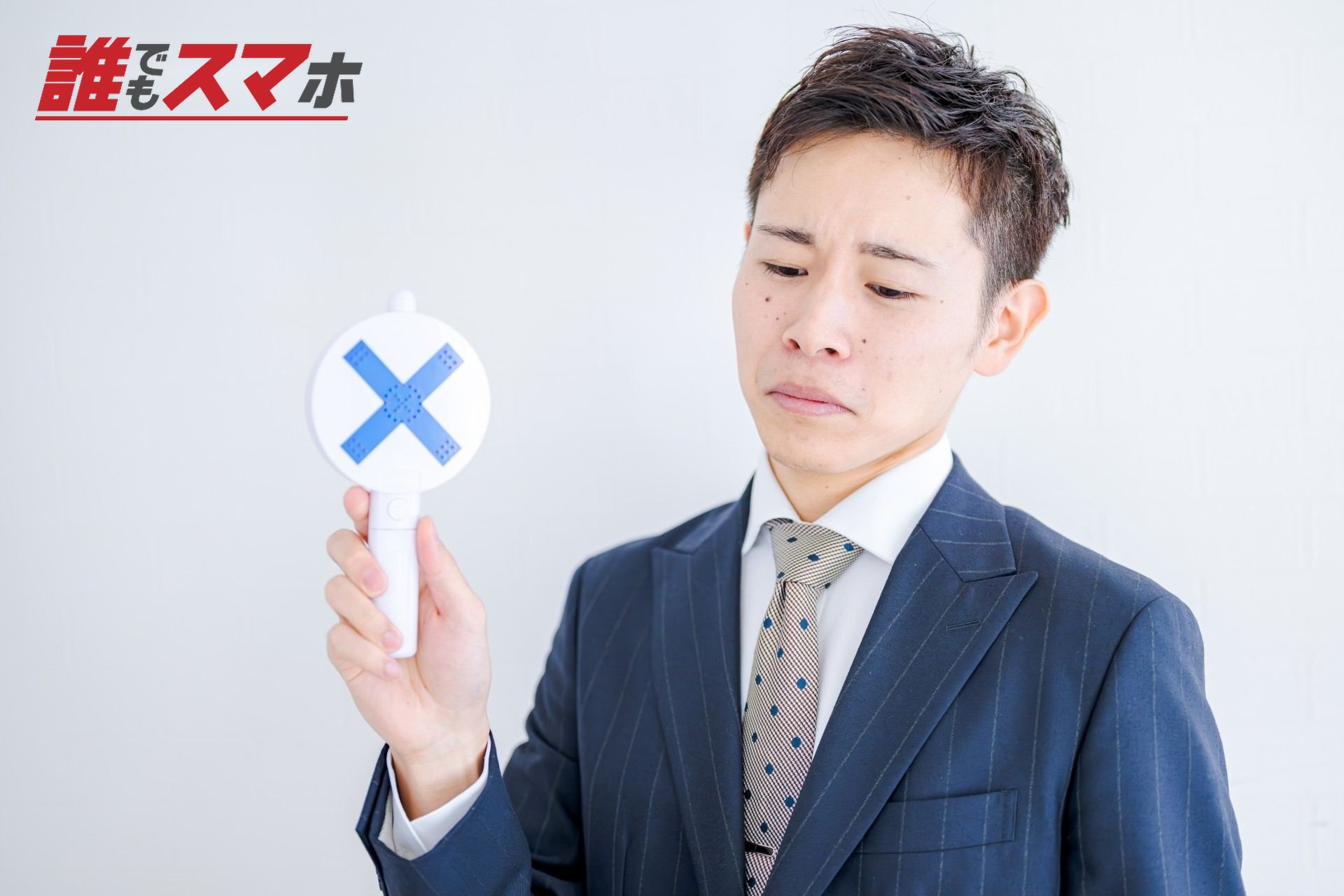 悲しそうに×を出すビジネスマン