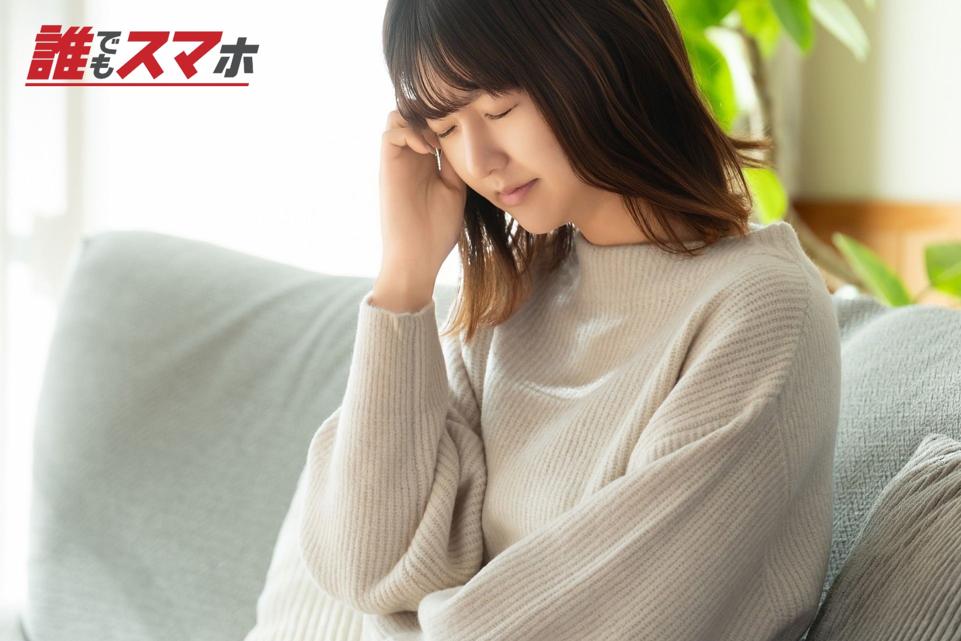 頭を押さえて悩む女性
