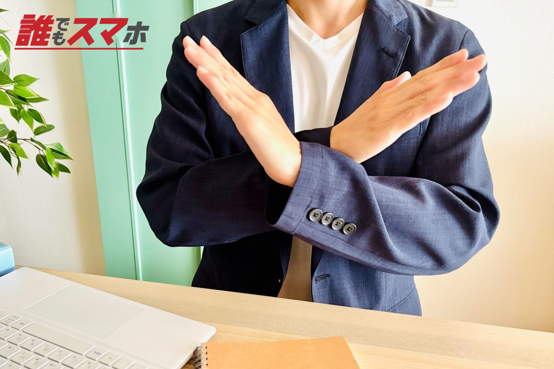 手でバツマークを作る男性