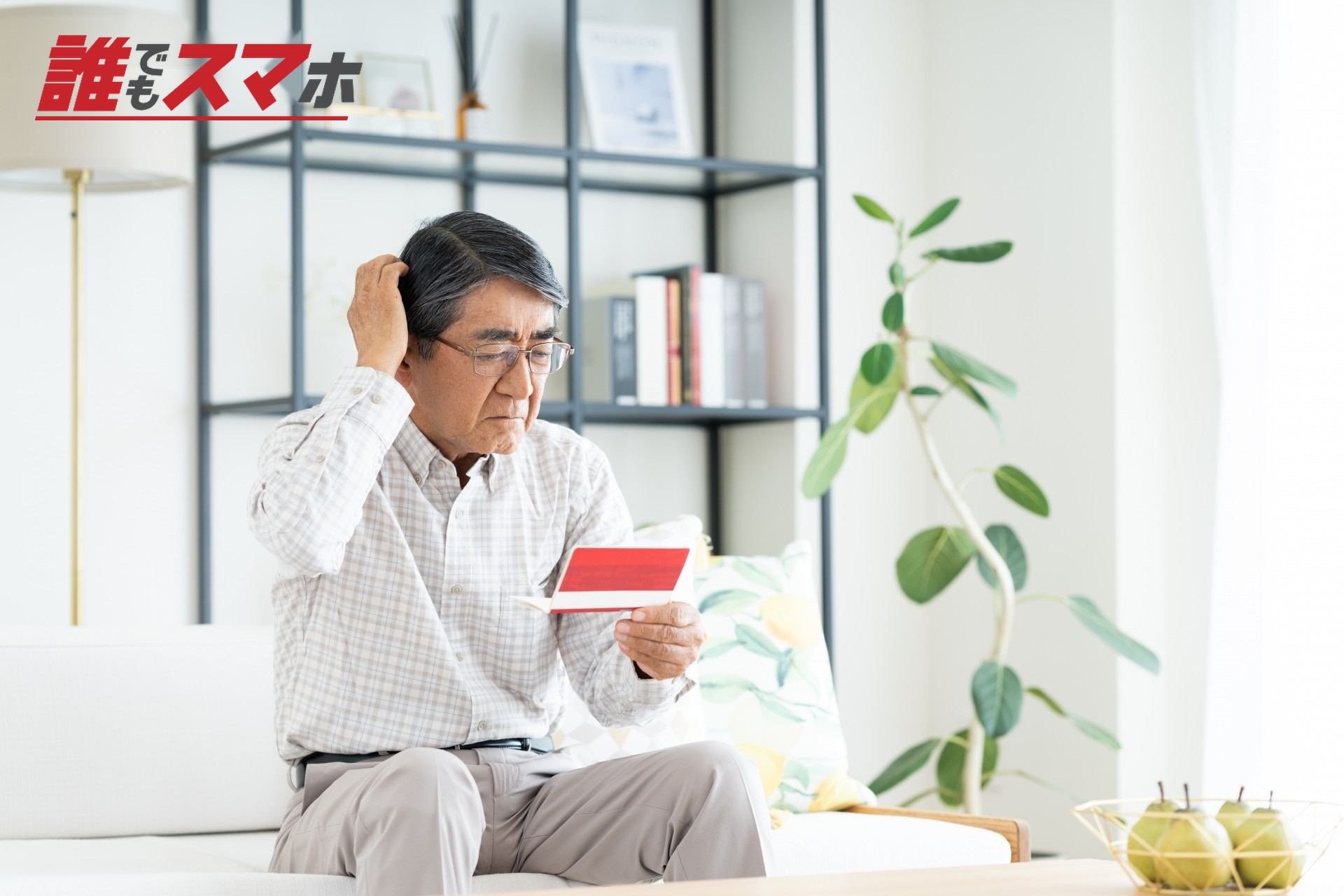通帳を見て悩むシニアの男性