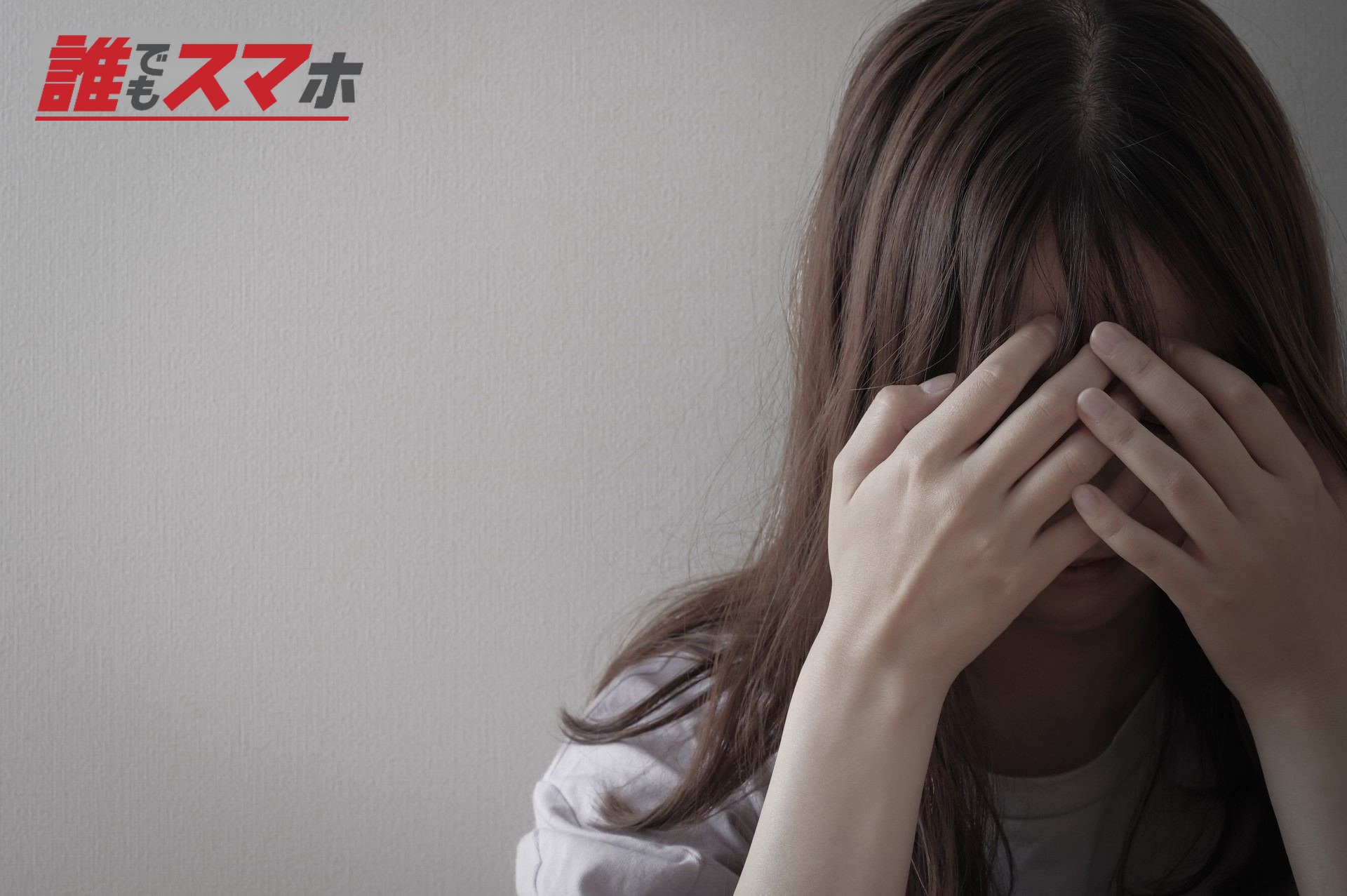 頭を抱える、辛そうな若い女性