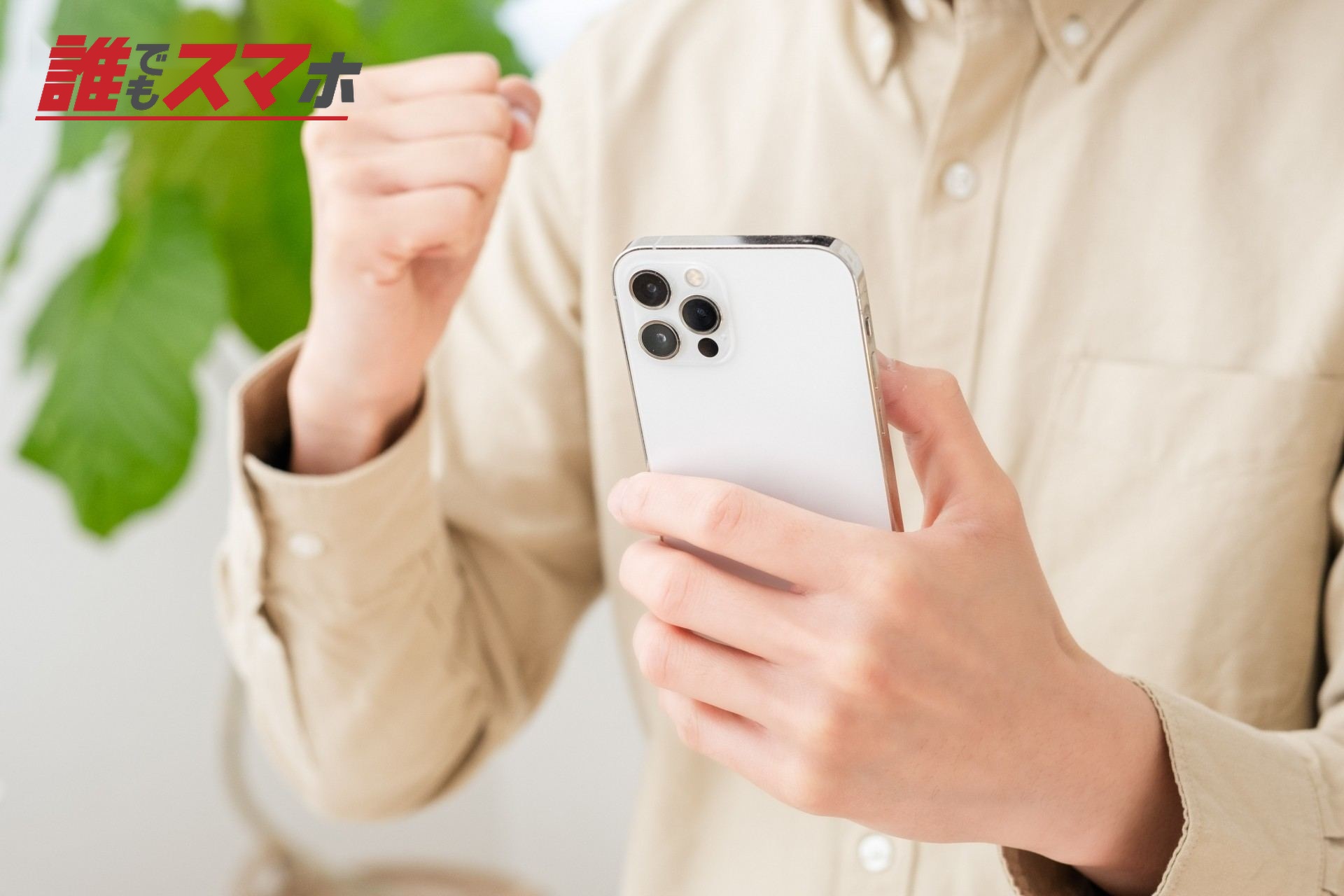 スマホを持ってガッツポーズする男性