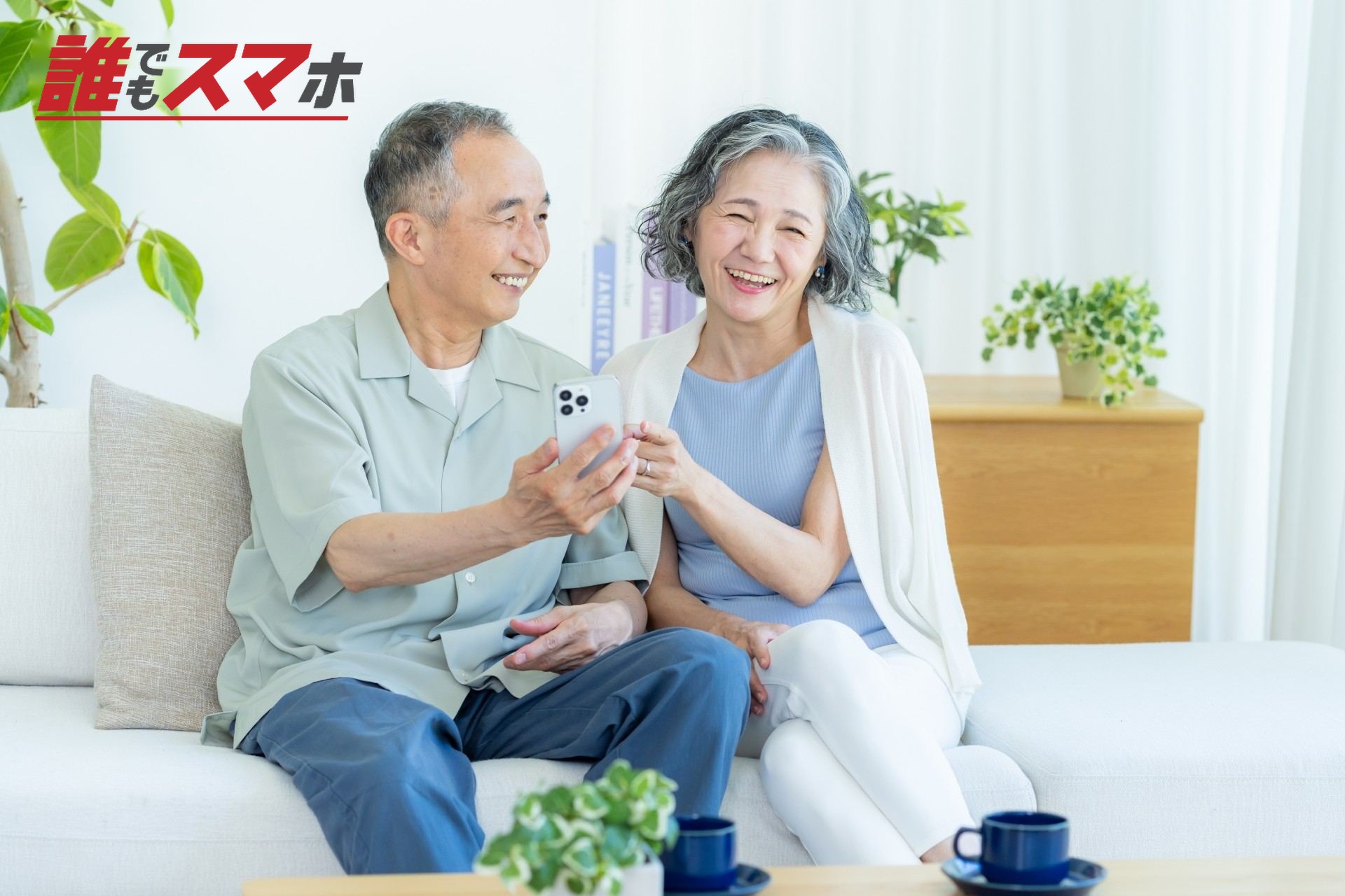 リビングでスマホを見るシニア夫婦