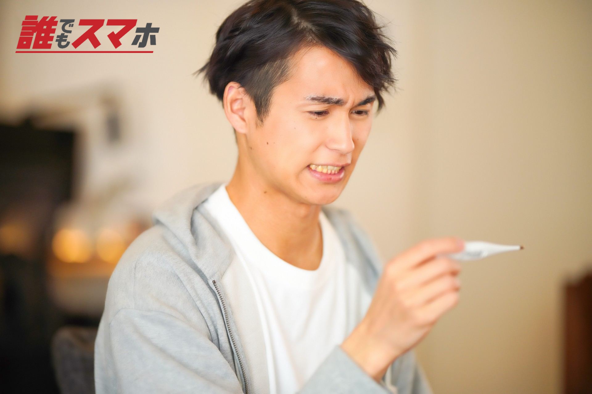 熱を測った体温計を見る男性2