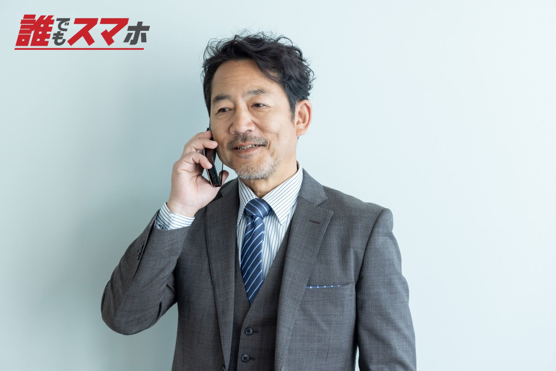 スマートフォンで話すビジネスパーソン
