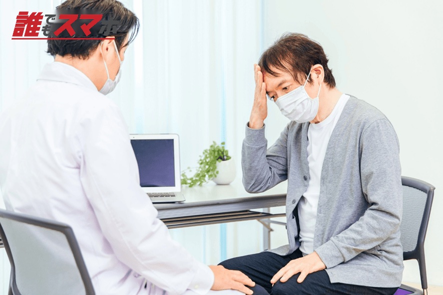 パソコンで診察するマスク姿の男性医師(頭痛)