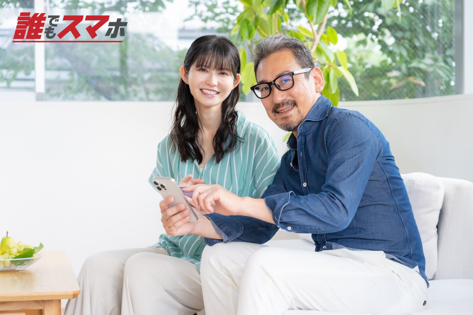 リビングでスマホを見るミドルの夫婦