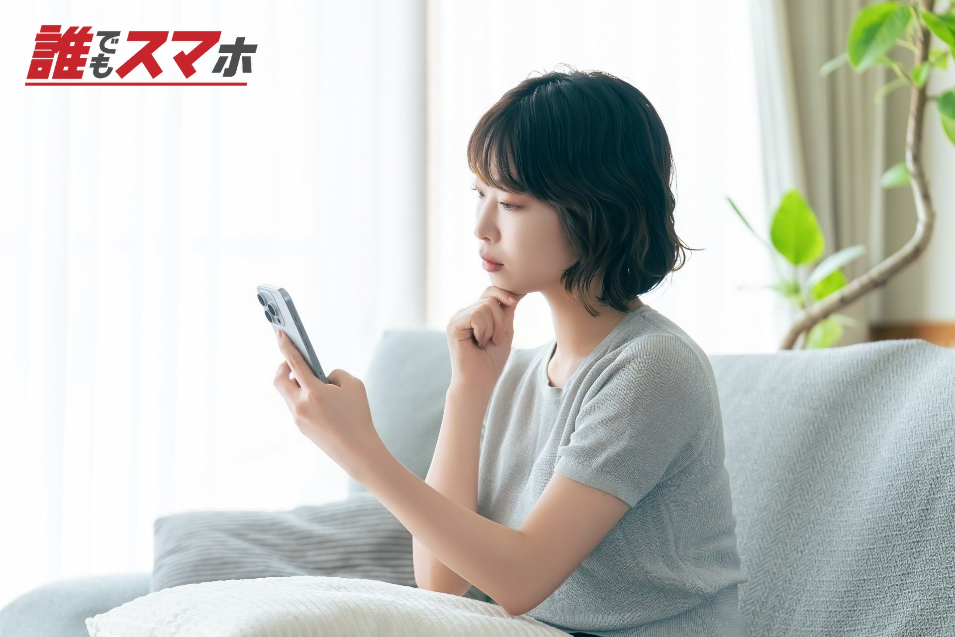 スマホを見て考えごとをする女性