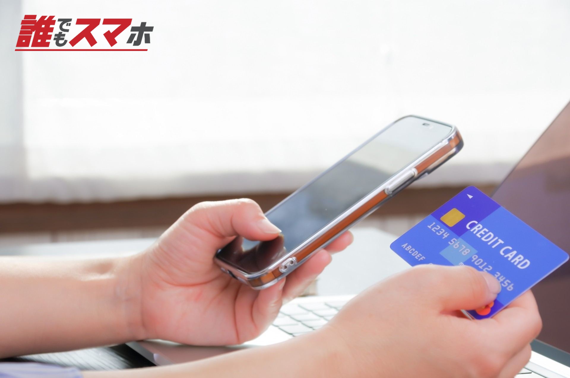 スマホとクレジットカードを持つ女性