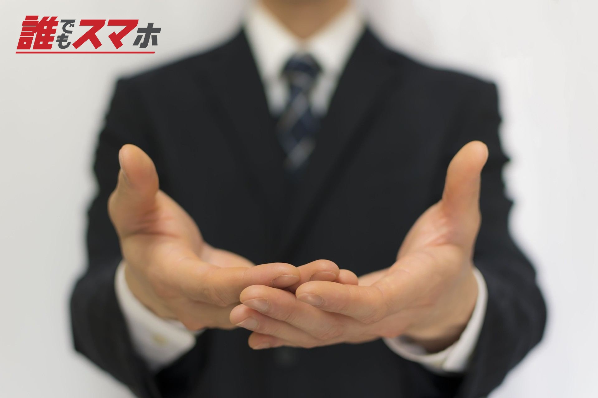 両手を重ねて差し出すスーツの男性
