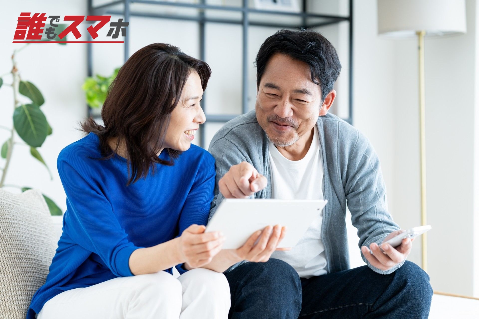 リビングでタブレットを使うミドルの夫婦