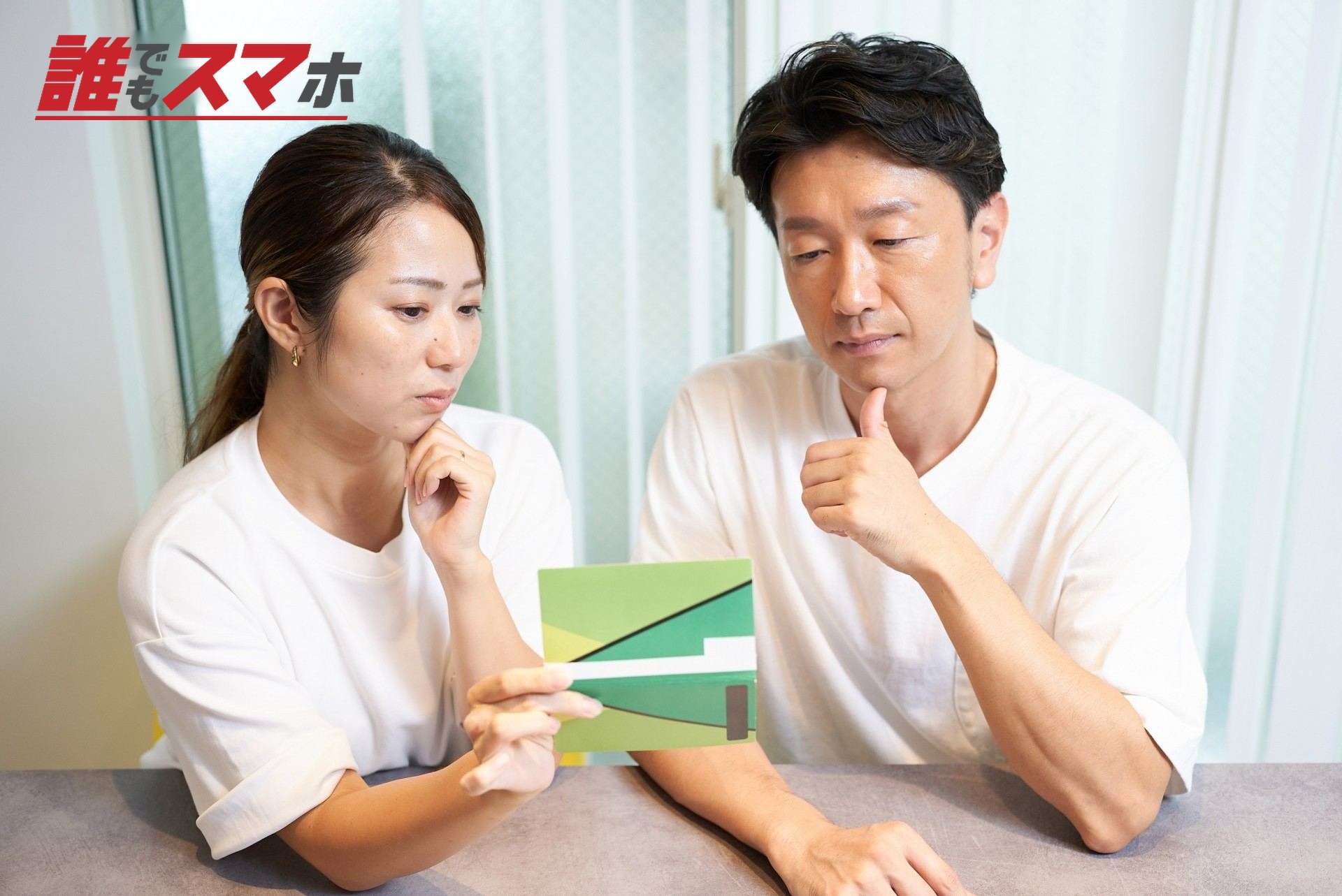 通帳を見て考え込む男女