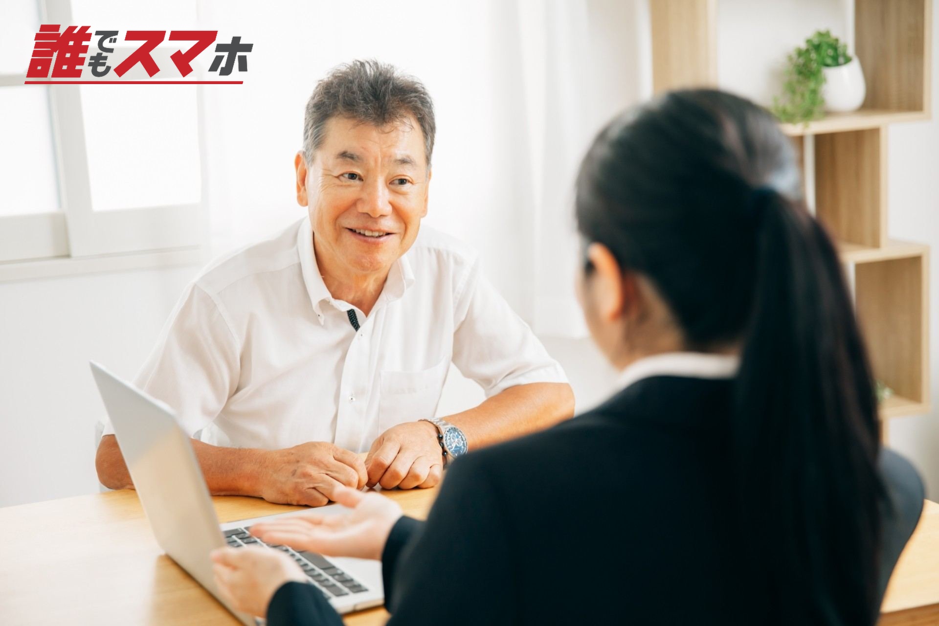 打ち合わせするスーツ姿の女性と高齢者男性