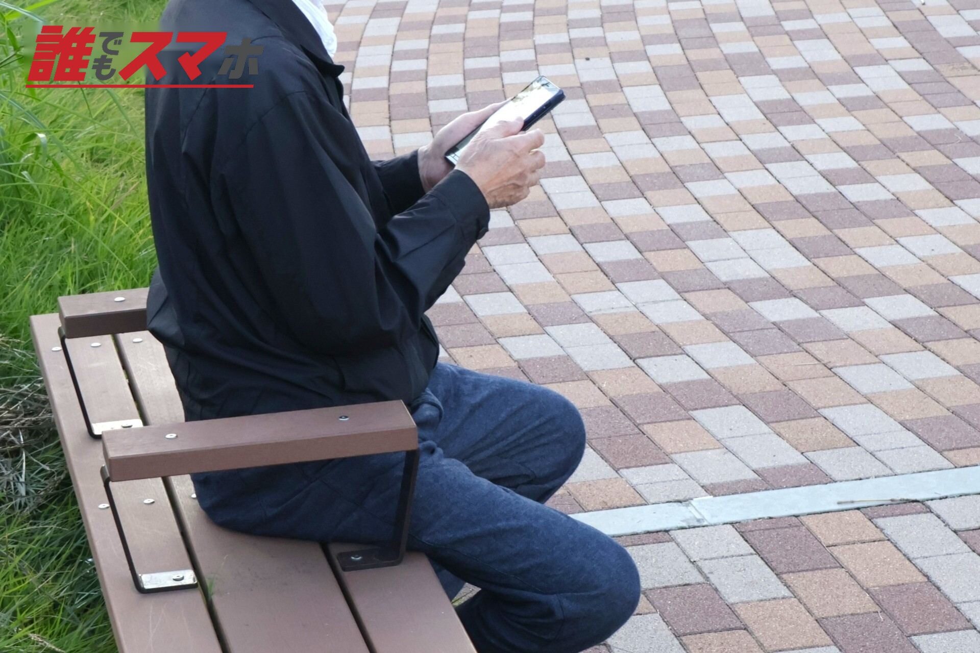 ベンチでスマホを見る人