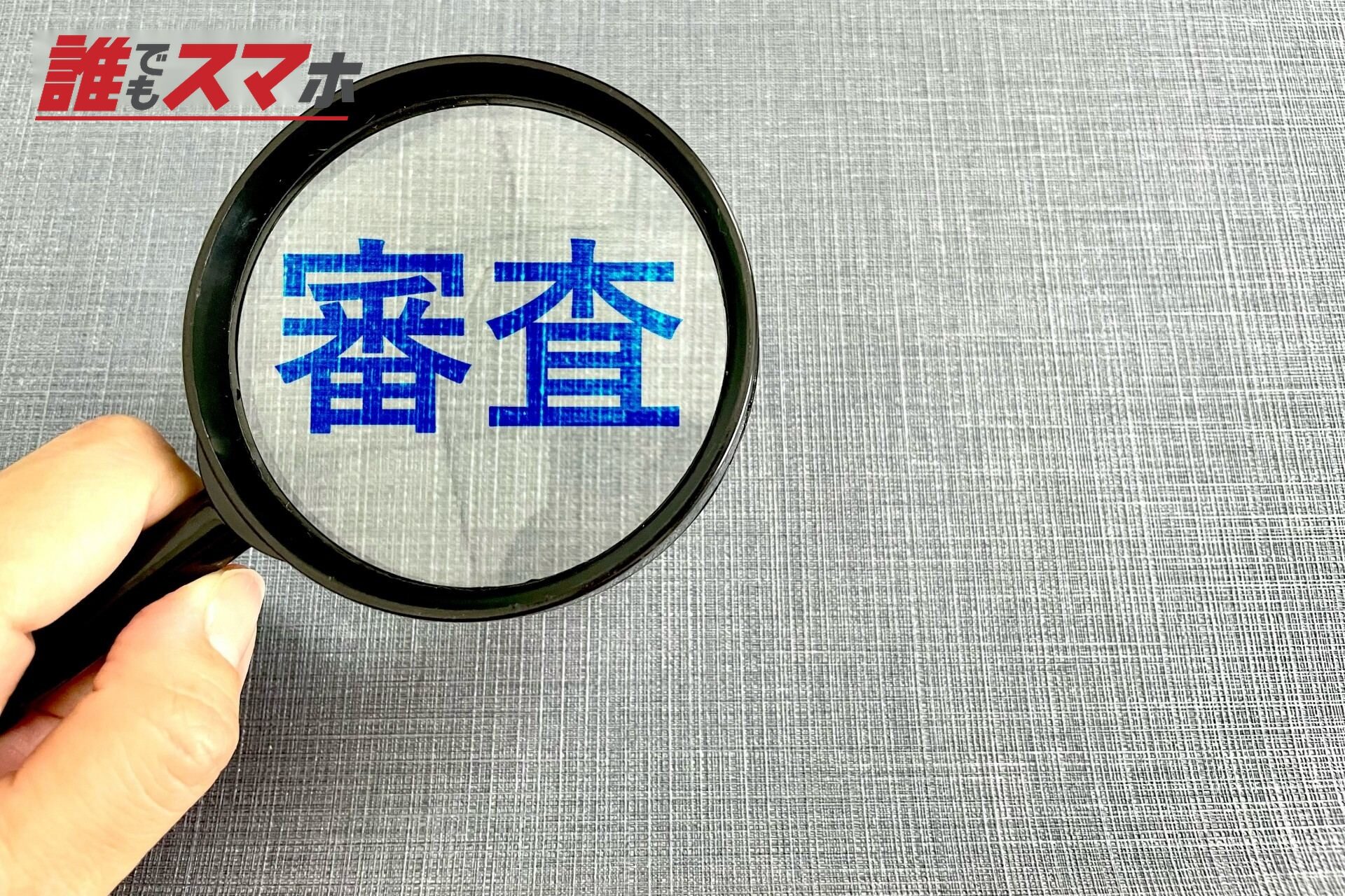 審査の文字と虫眼鏡と手 ビジネスの審査