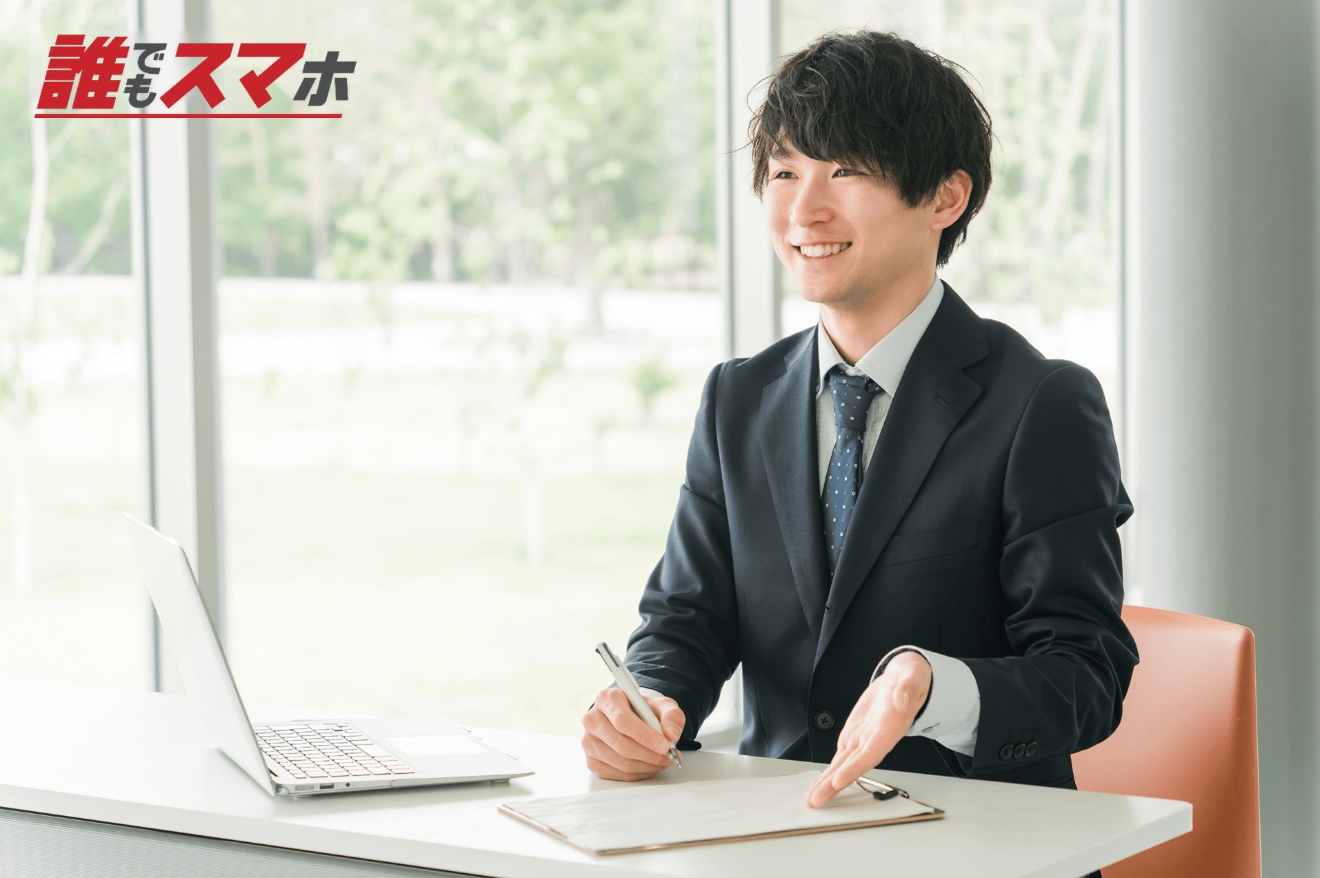 デスクに座って案内をする男性