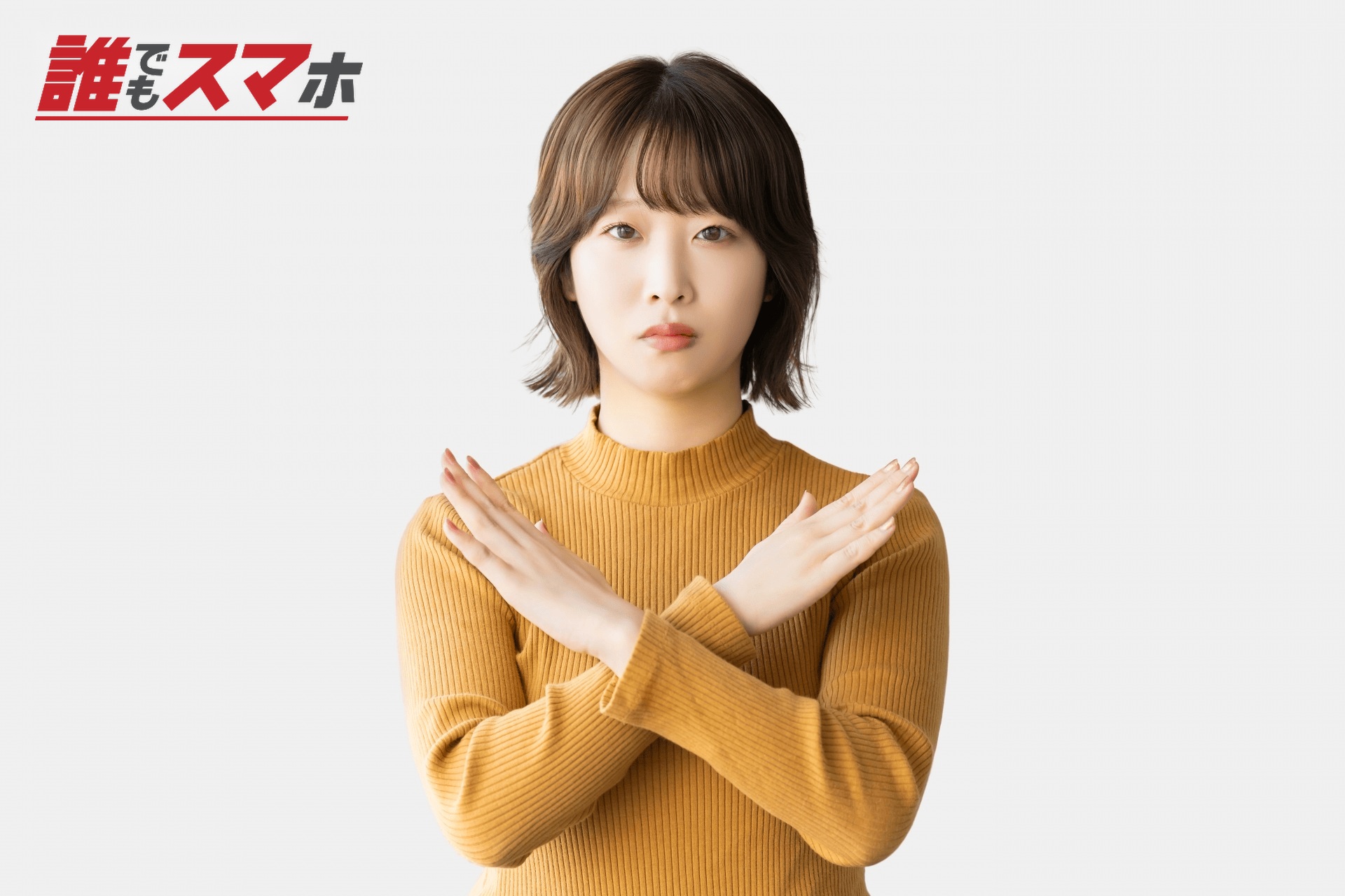 手でバツのポーズをする困った表情の女性