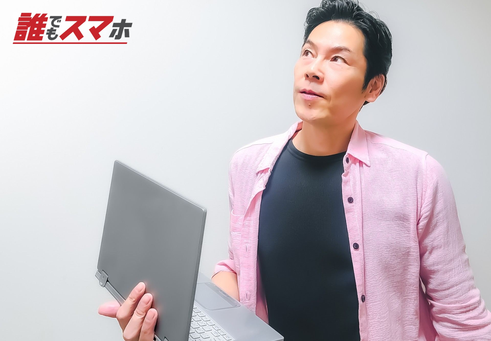 パソコンを持って考えている男性