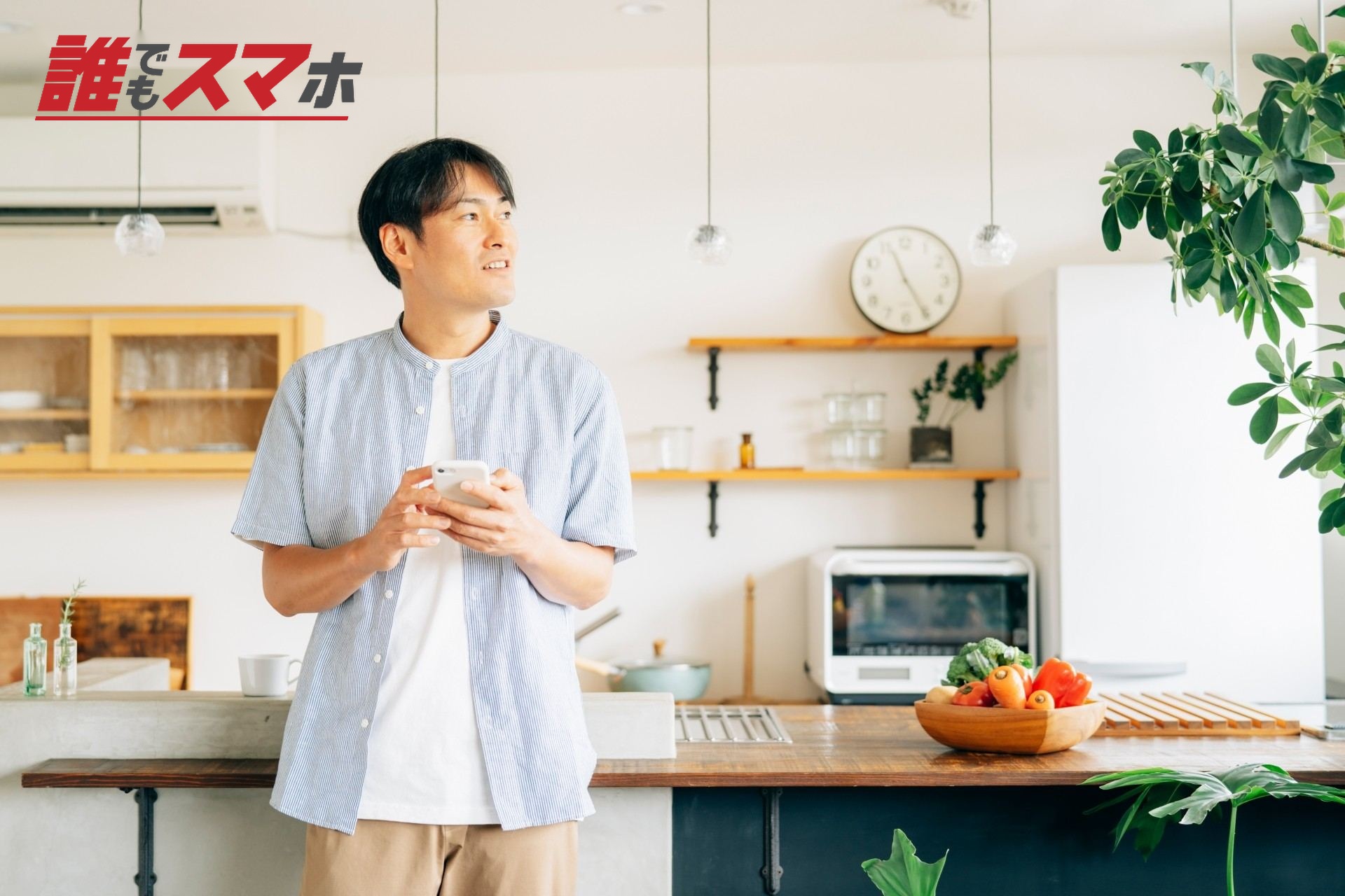 家でスマホを使う男性(アプリ)