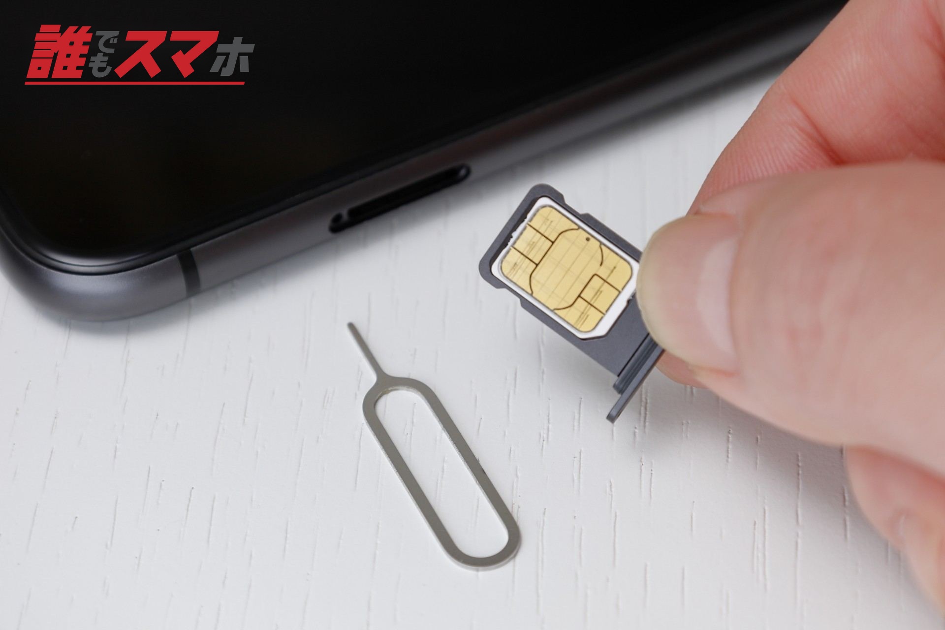 スマートフォンにSIMをセットする右手