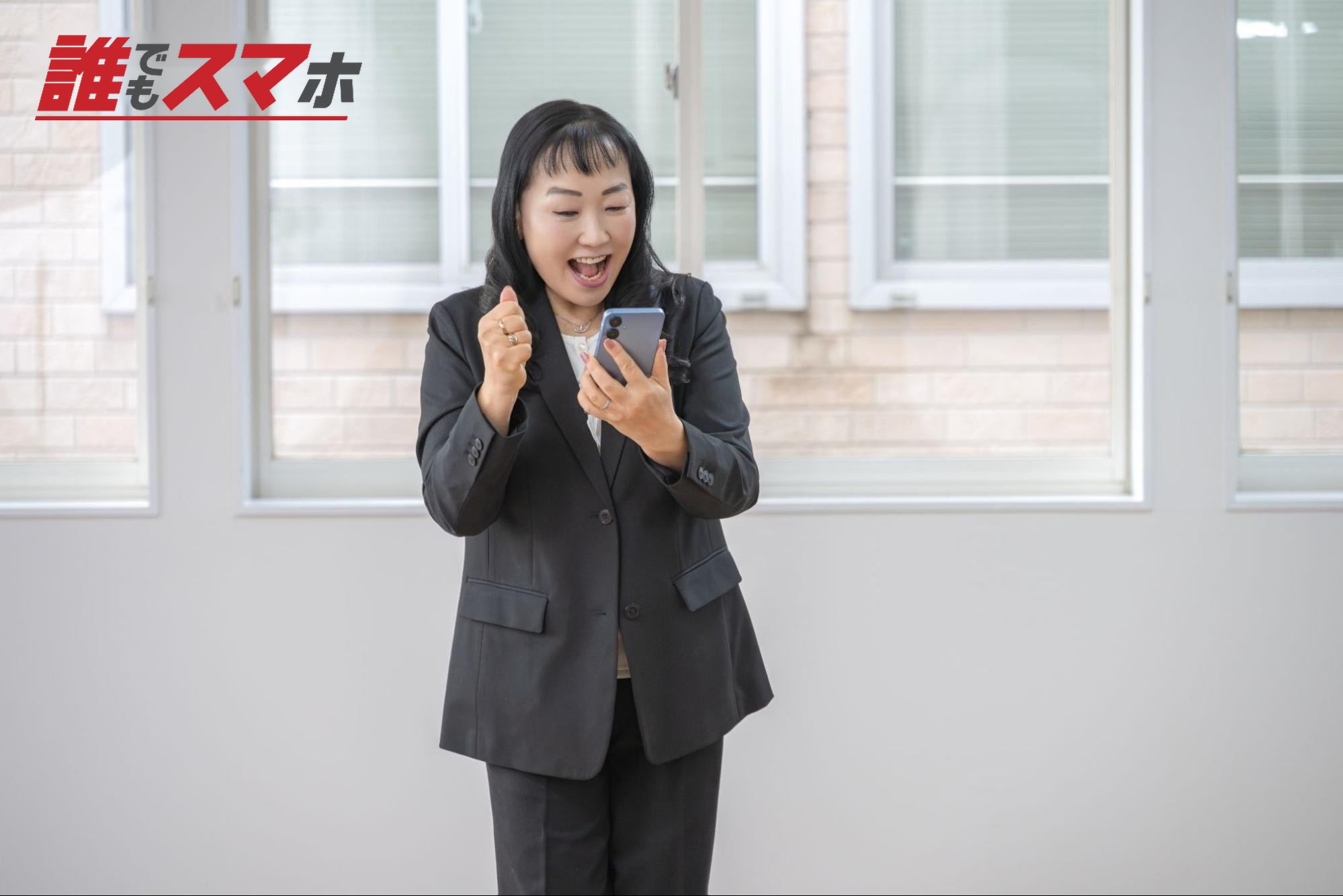 スマホを見て喜ぶビジネスウーマン