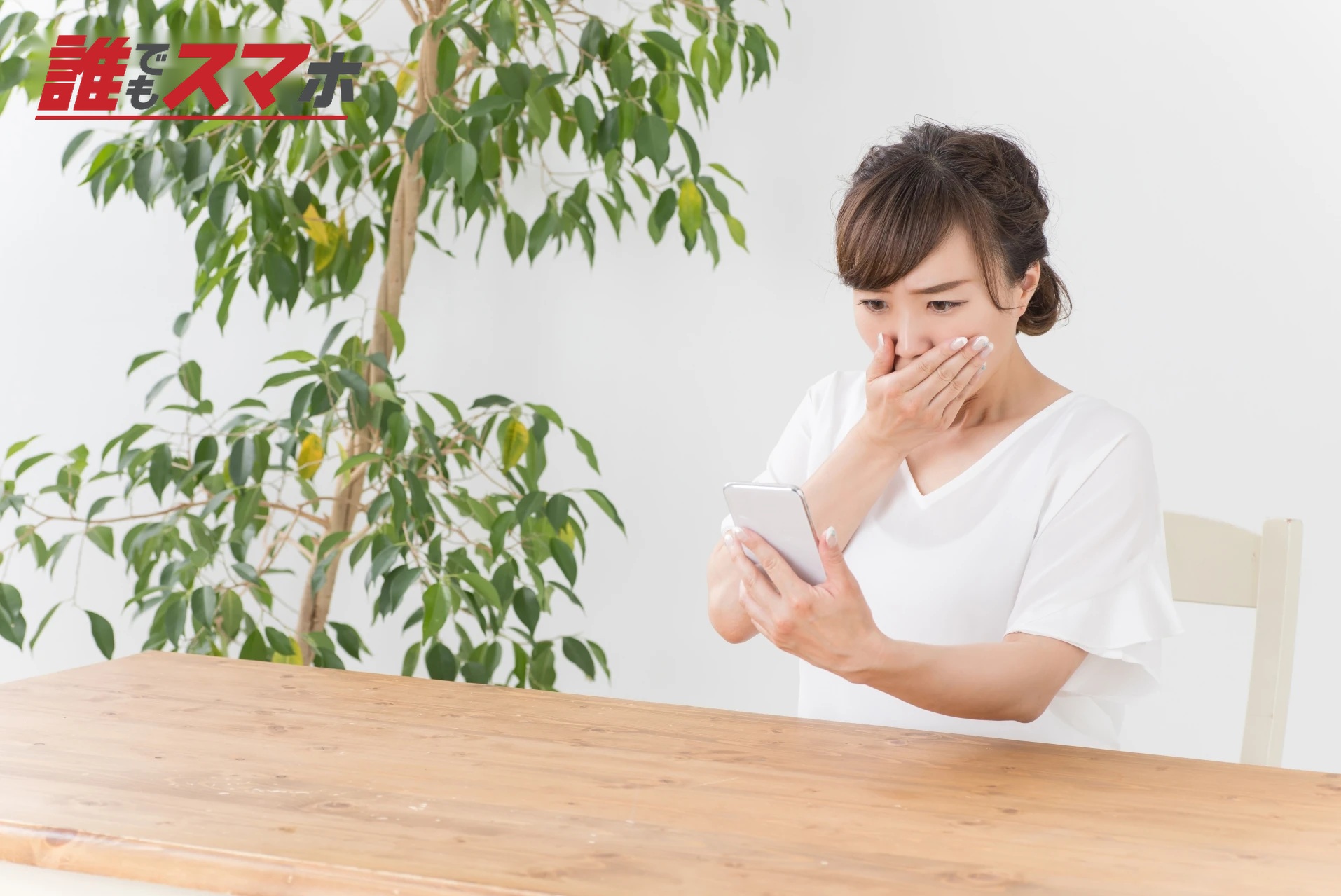 スマホを見て驚く女性
