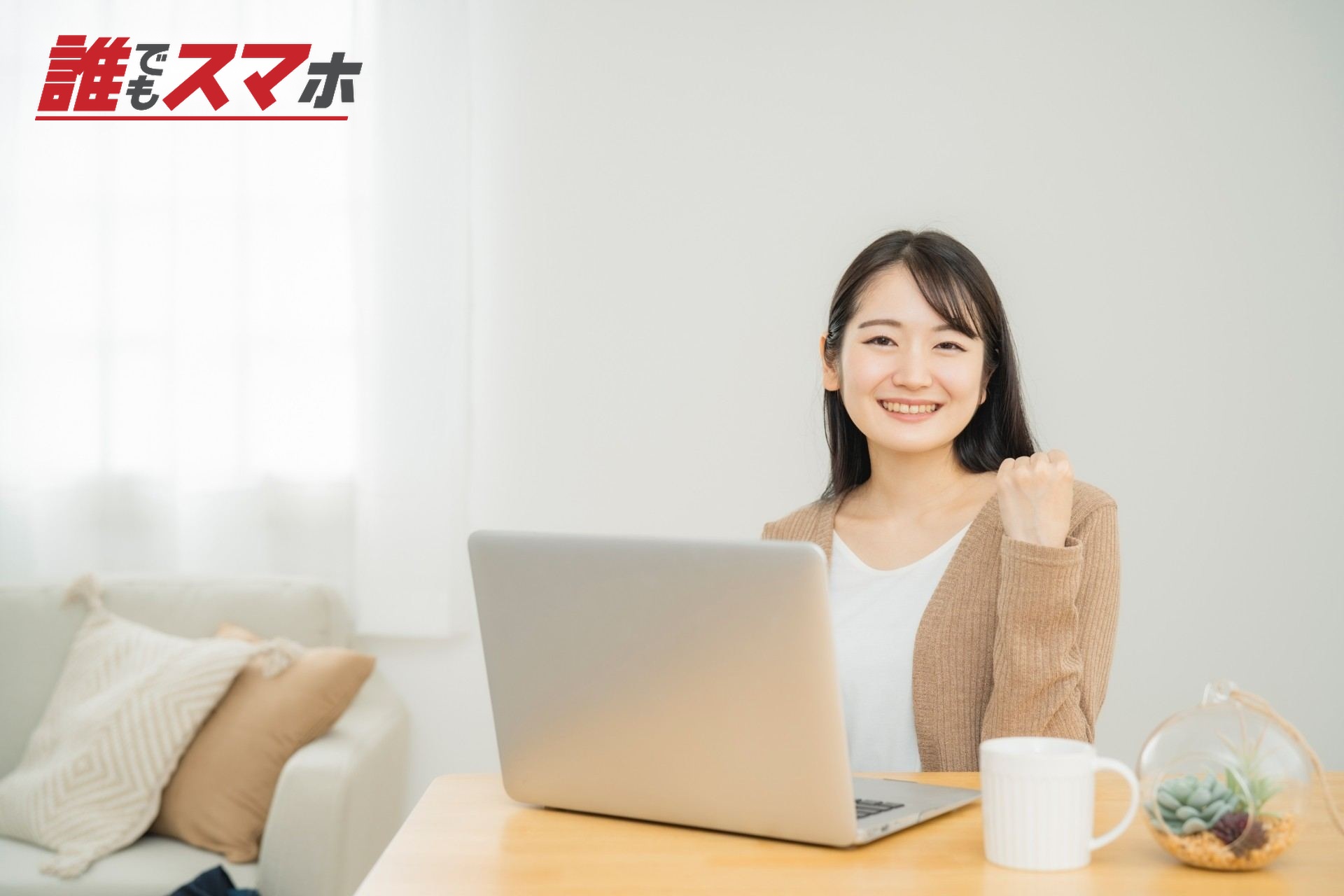 家でノートパソコンを使う女性(ガッツポーズ)
