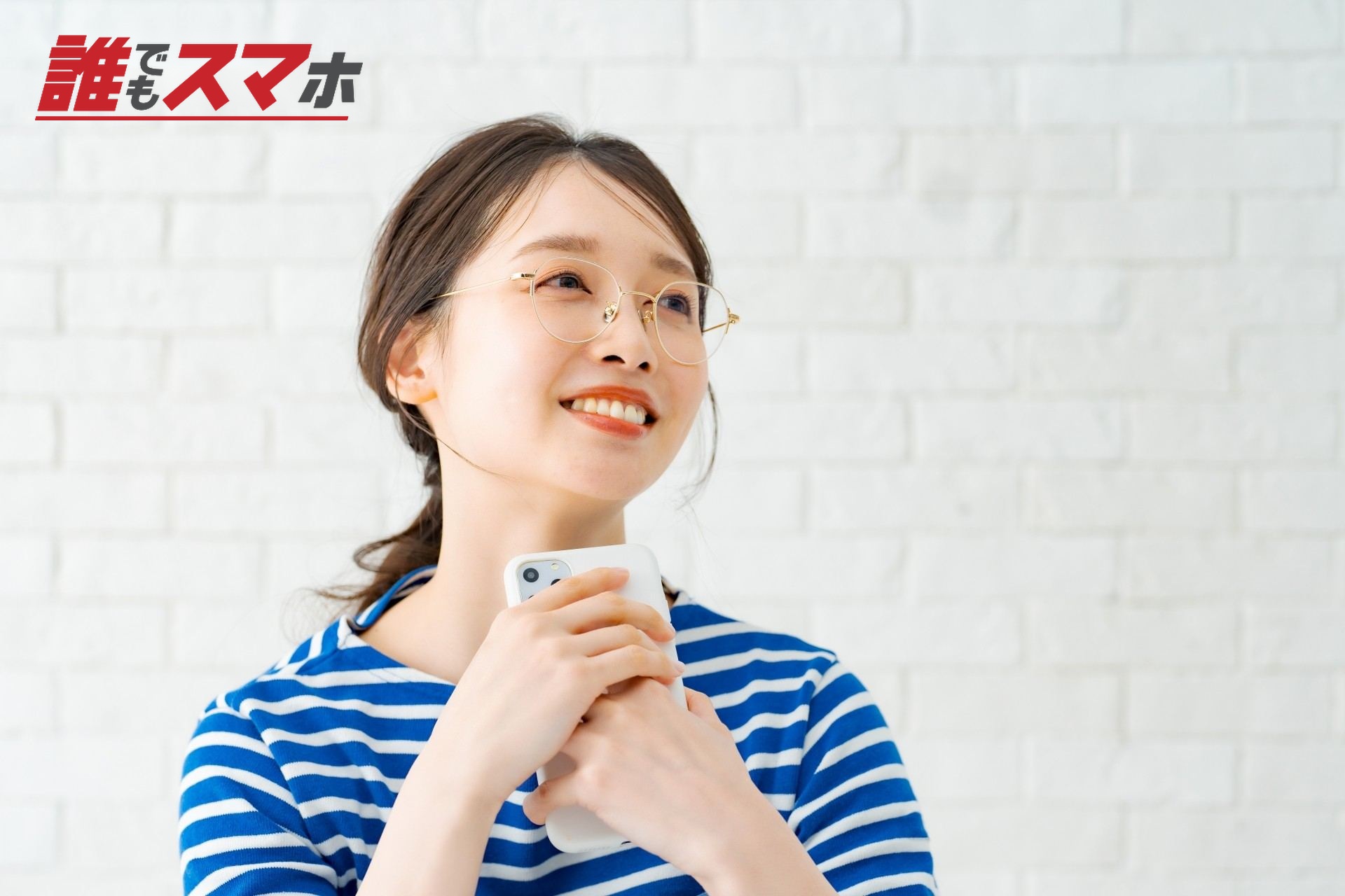 スマートフォンを手に笑顔のメガネ女子