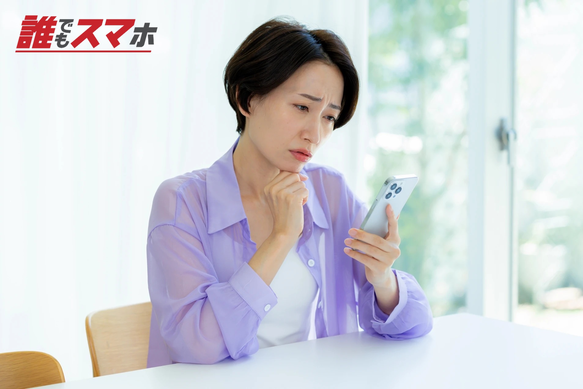 スマホを見て悩む女性